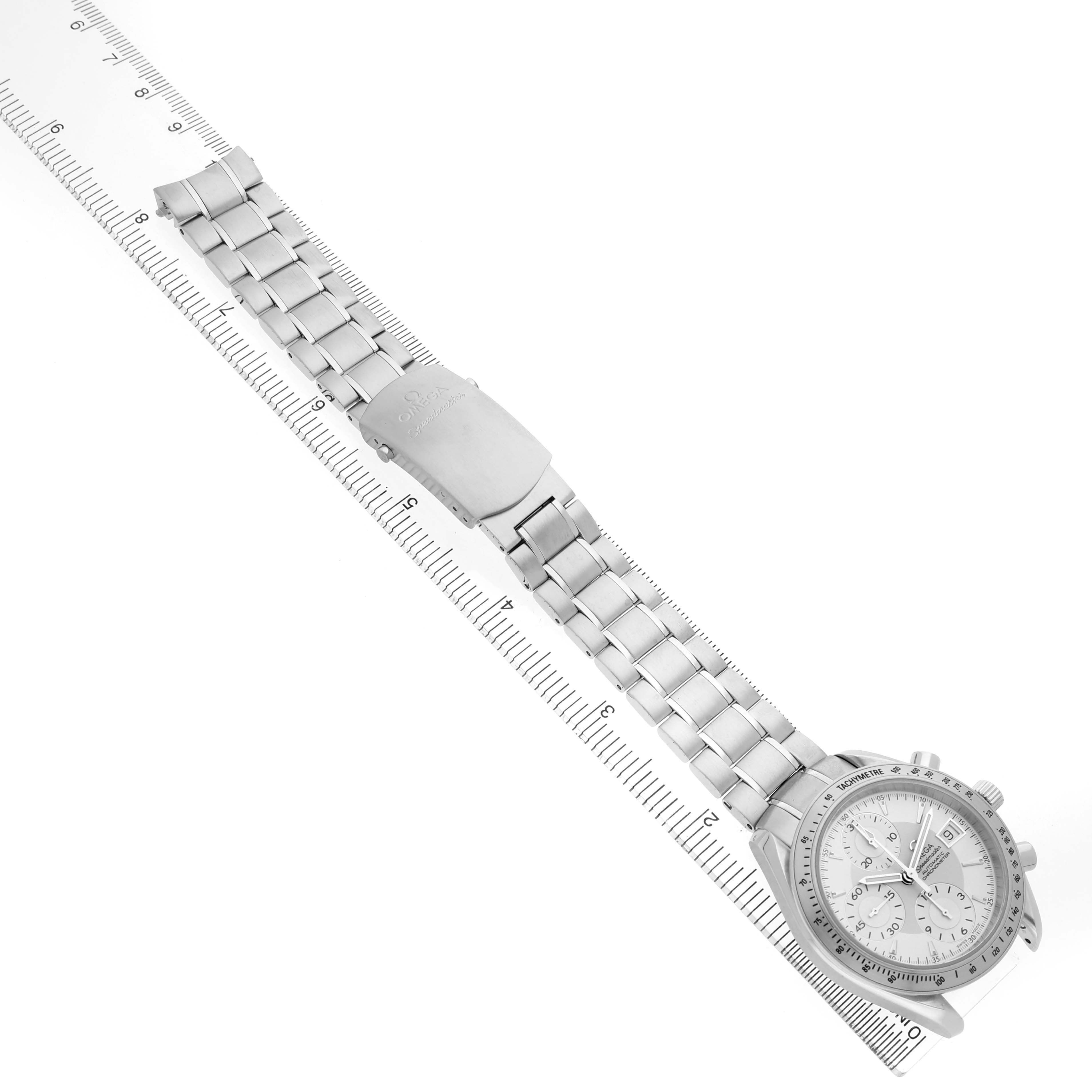 The Omega Speedmaster 3211.30.00 Men's Stainless Steel Silver Dial watch is shown at an angled top view displaying its full face and metal bracelet alongside a ruler.
