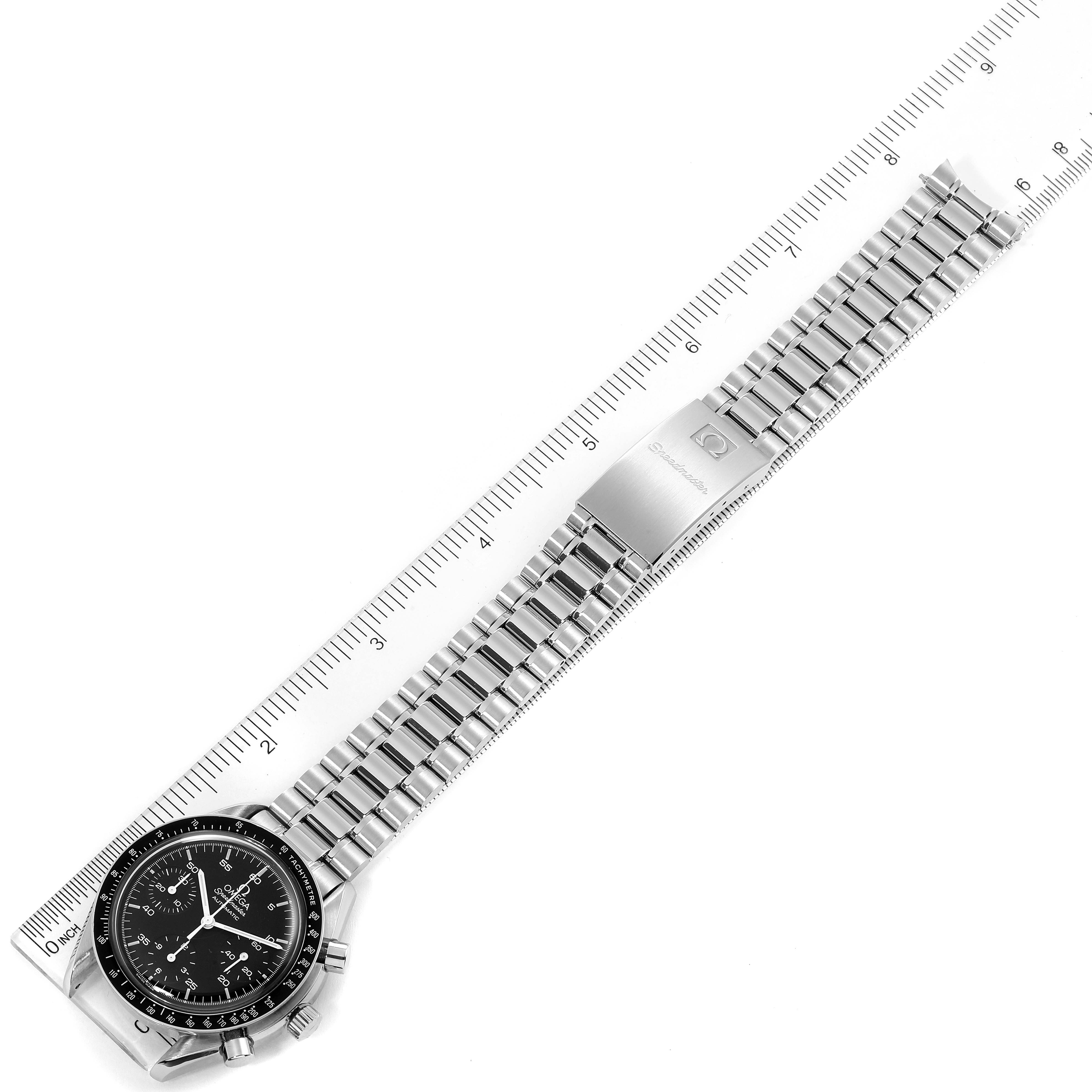The image shows an overhead view of an Omega Speedmaster 3510.50.00 Men
s Stainless Steel Black Dial 3510.50.00 Men
s Stainless Steel Black Dial watch with its stainless steel bracelet stretched out along a ruler.