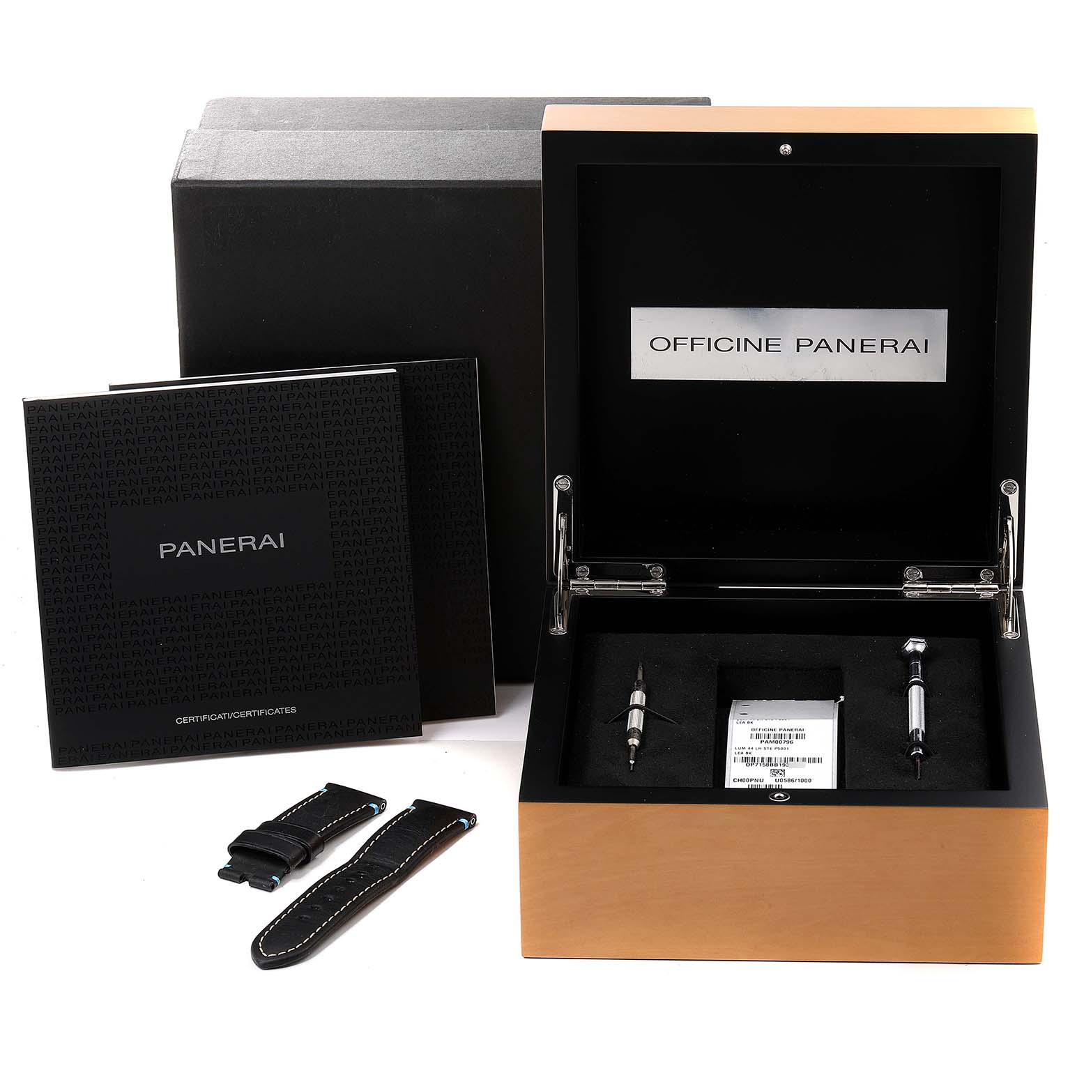 The image shows an unboxing of a Panerai Luminor PAM00796 Men
s Stainless Steel Black Dial PAM00796 Men
s Stainless Steel Black Dial watch with its accessories including tools, extra straps, and documentation.