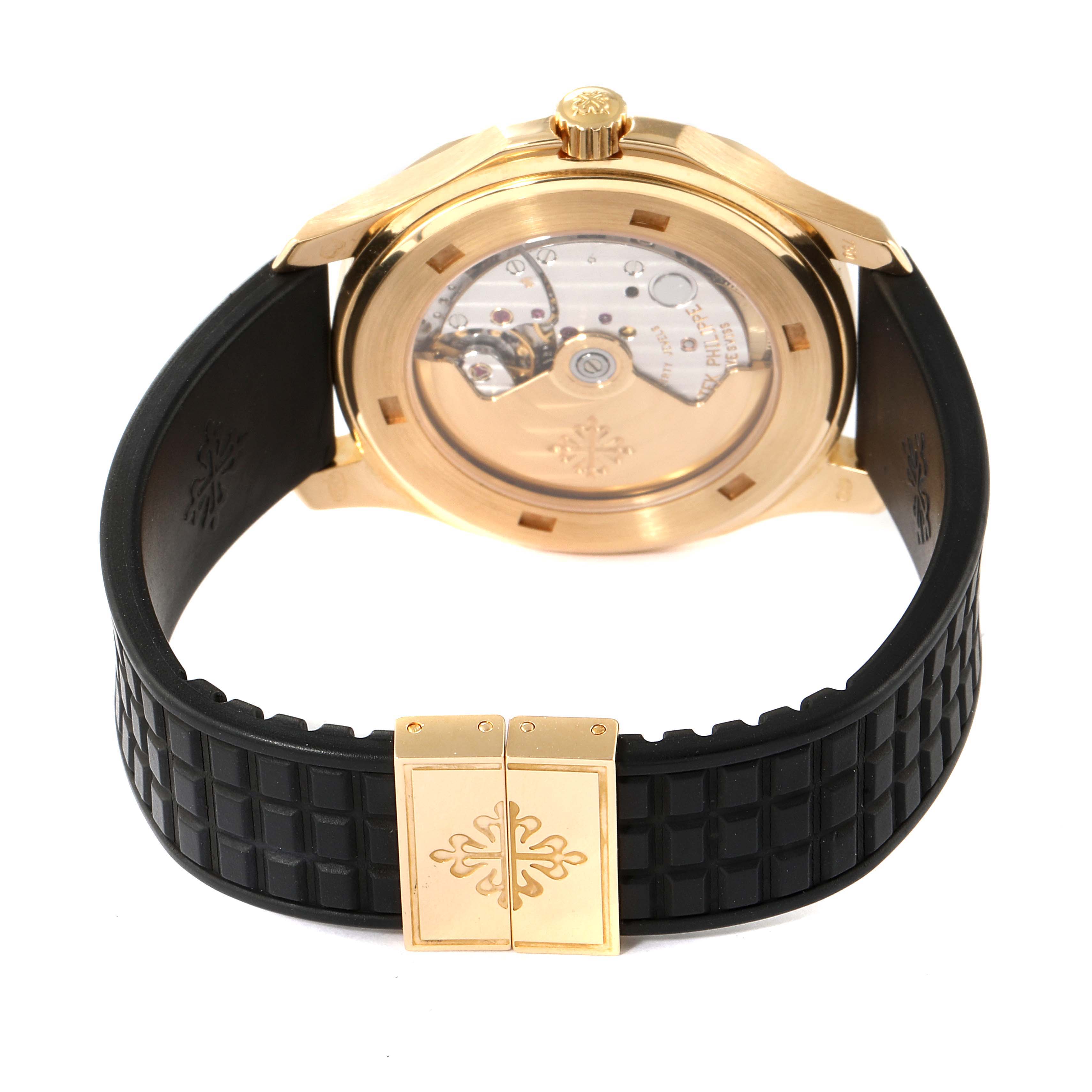 This image shows the back view of a Patek Philippe Aquanaut 5065J Men's Yellow Gold Black Dial 5065J Men's Yellow Gold Black Dial watch, highlighting its movement and black rubber strap clasp.