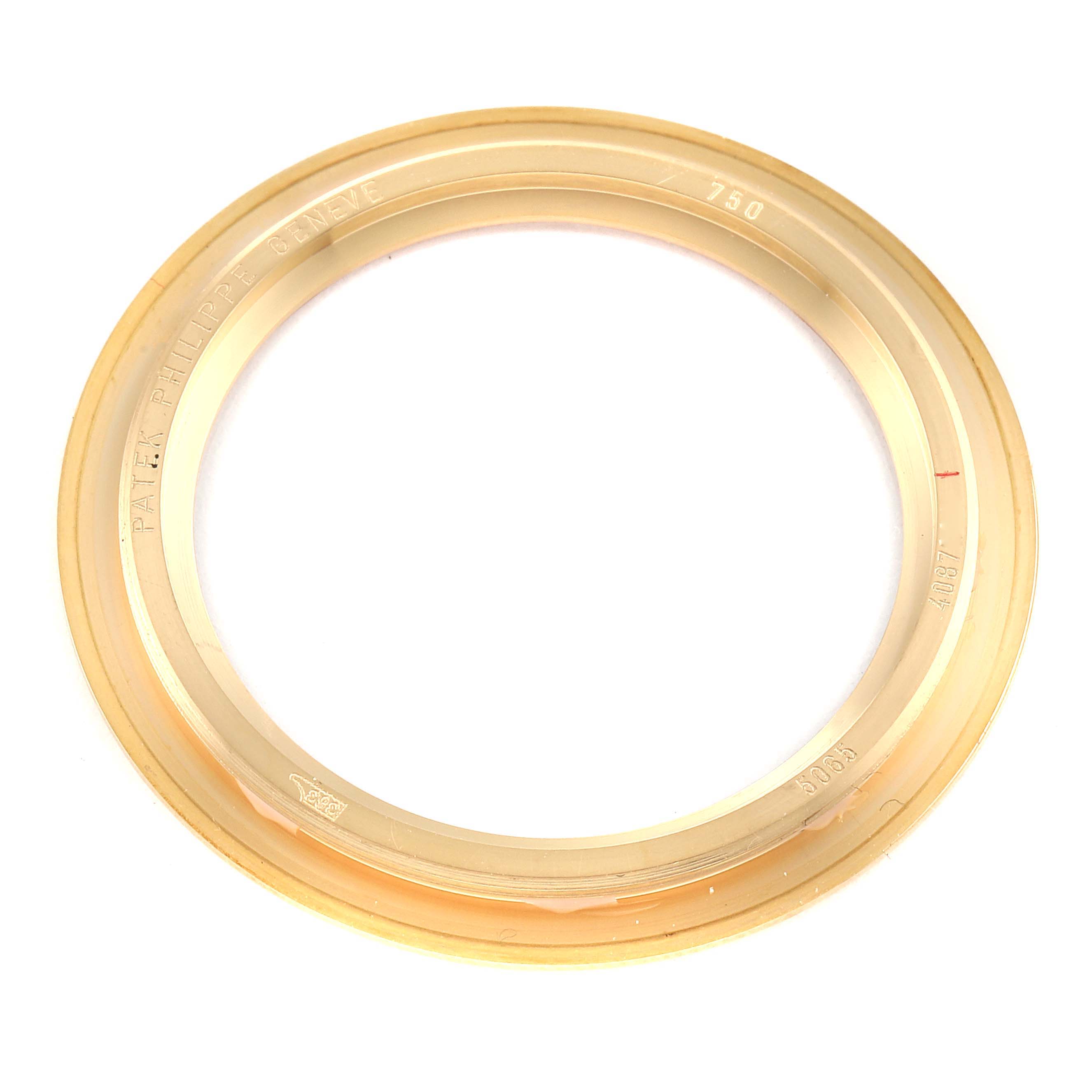 This image shows a gold bezel for a Patek Philippe Aquanaut 5065J Men's Yellow Gold Black Dial 5065J Men's Yellow Gold Black Dial watch, viewed from the top.