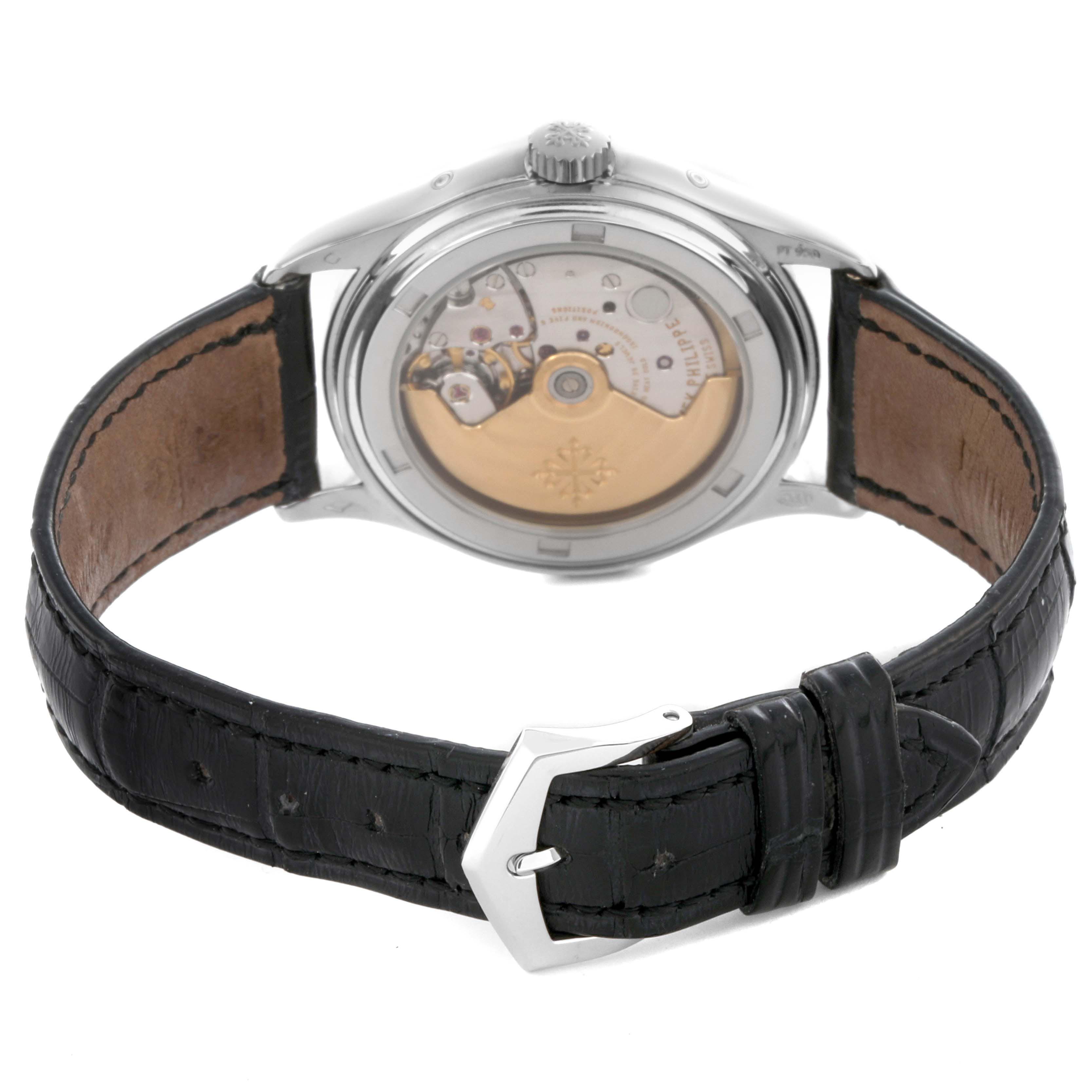 The image shows the back of a Patek Philippe Complications 5035P-024 Men's Platinum Grey Dial 5035P-024 Men's Platinum Grey Dial watch, highlighting the movement and black leather strap.