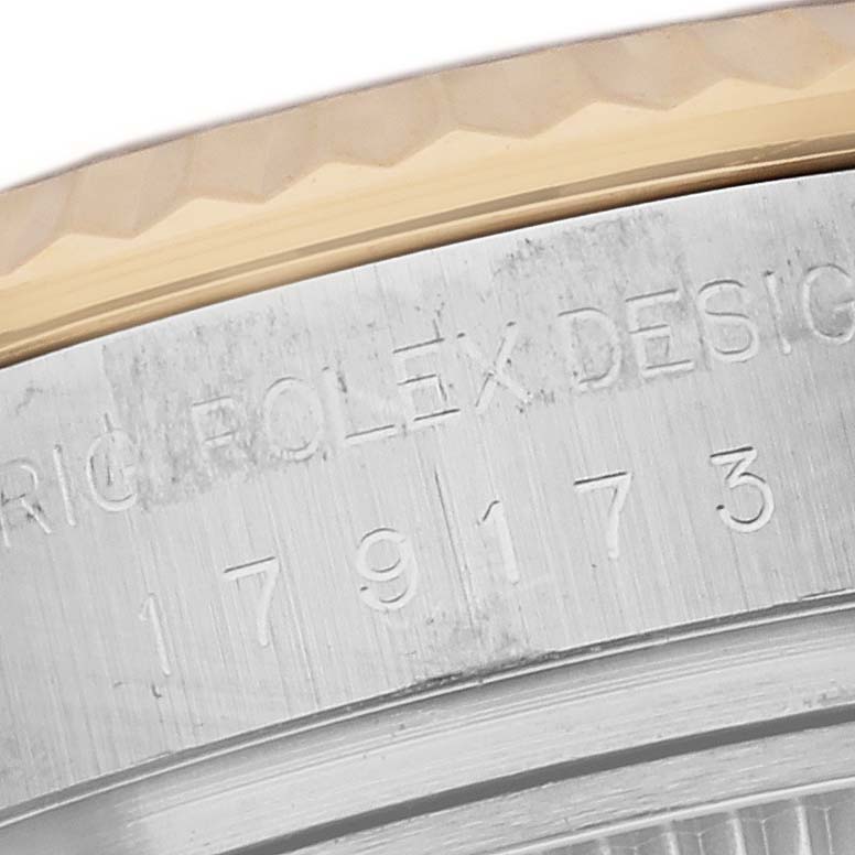 This image shows a close-up of the side detail of the bezel and engraved text on a Rolex Datejust 179173 Men's Steel and Gold (two tone) Silver Dial 179173 Men's Steel and Gold (two tone) Silver Dial watch.