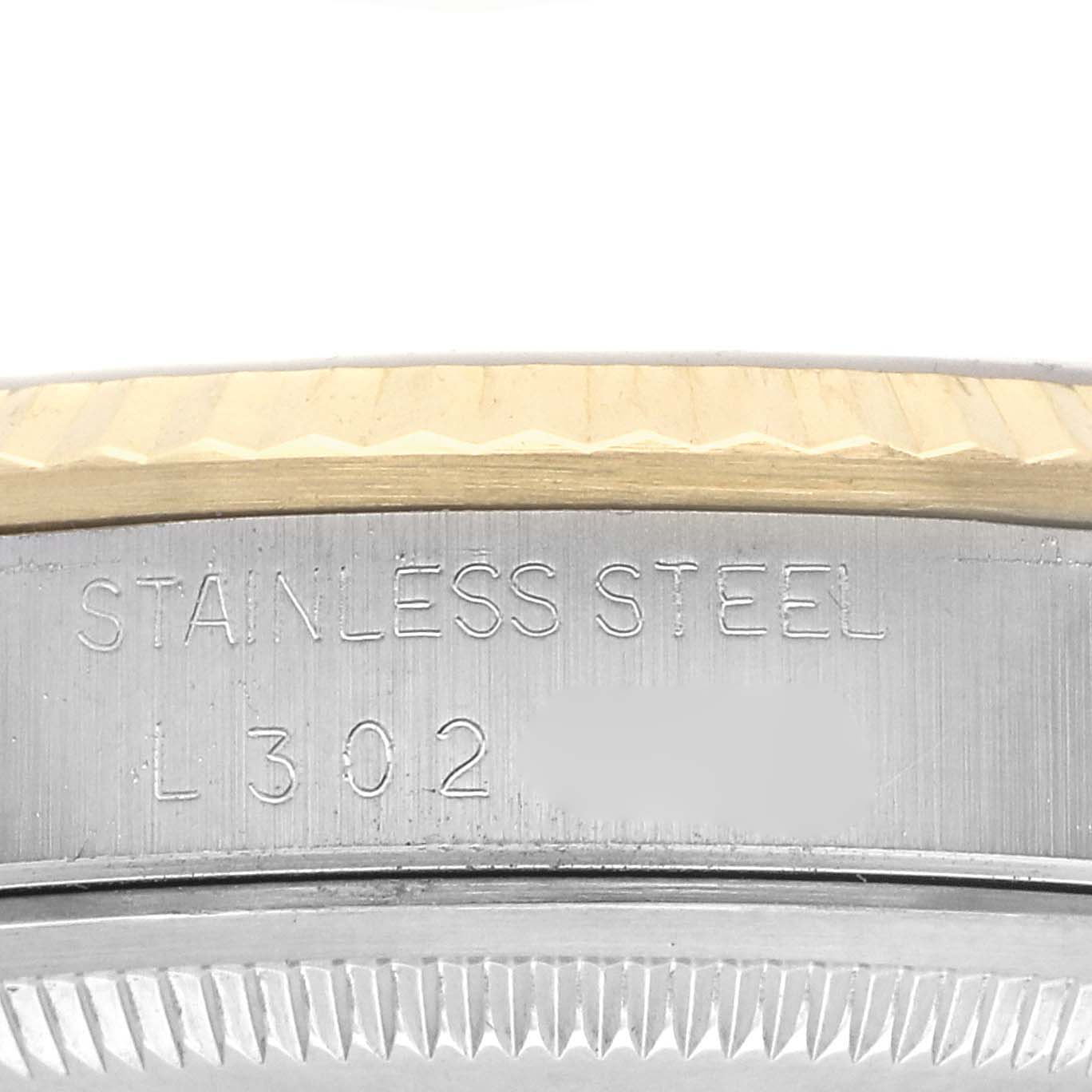 The image shows a detailed view of the case side of a Rolex Datejust 16233 Men
s Steel and Gold (two tone) Champagne Dial 16233 Men
s Steel and Gold (two tone) Champagne Dial, highlighting the engraving and fluted bezel.