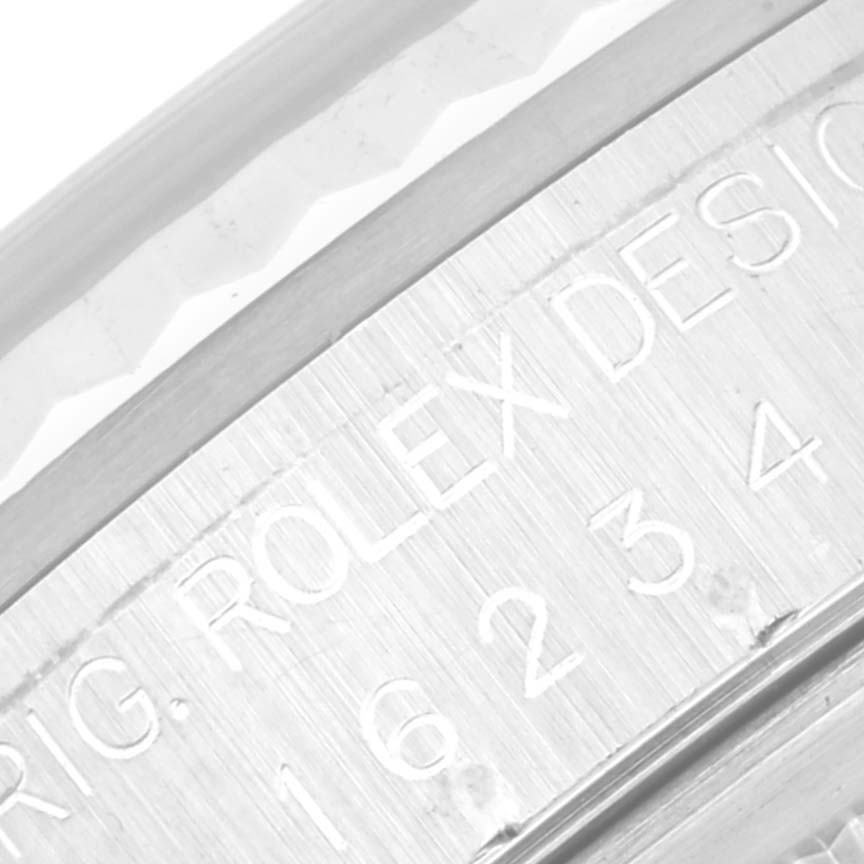 Close-up image of the side with engraved text of a Rolex Datejust 16234 Men's Stainless Steel Blue Dial 16234 Men's Stainless Steel Blue Dial wristwatch, showing part of the watch bezel and casing.