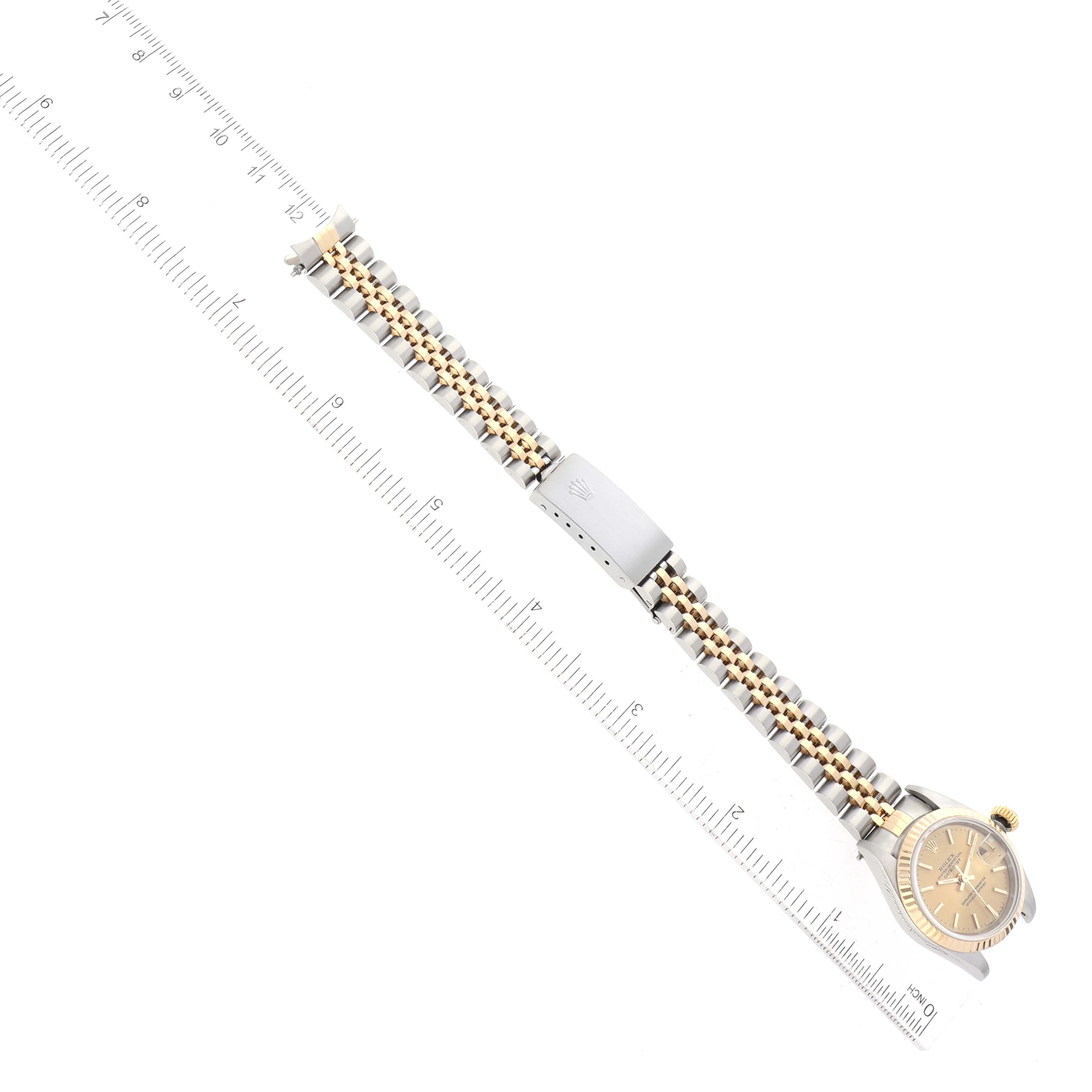The image shows a Rolex Datejust 69173 Women
s Steel and Gold (two tone) Champagne Dial 69173 Women
s Steel and Gold (two tone) Champagne Dial watch laid flat, fully displaying the bracelet and face with a ruler beside it for scale.