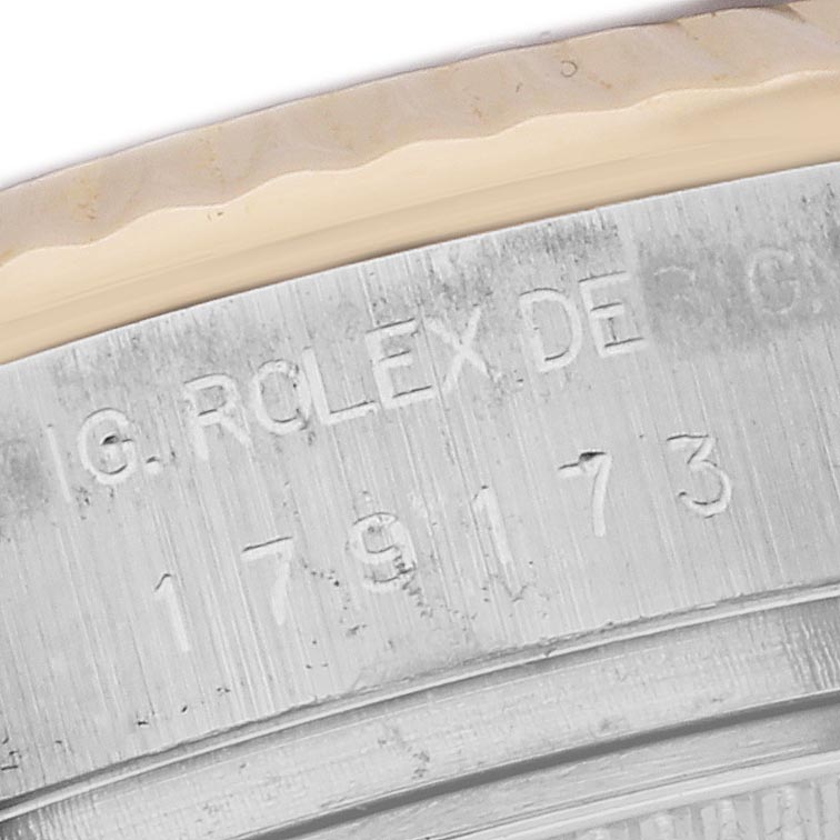 The image shows a close-up of the engraved serial number and fluted bezel on a Rolex Datejust 179173 Women's Steel and Gold (two tone) Champagne Dial 179173 Women's Steel and Gold (two tone) Champagne Dial watch.