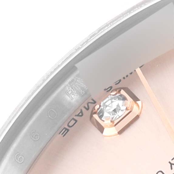 This close-up image shows the dial and bezel of a Mid-Size Rolex watch, highlighting a diamond marker and partial text.