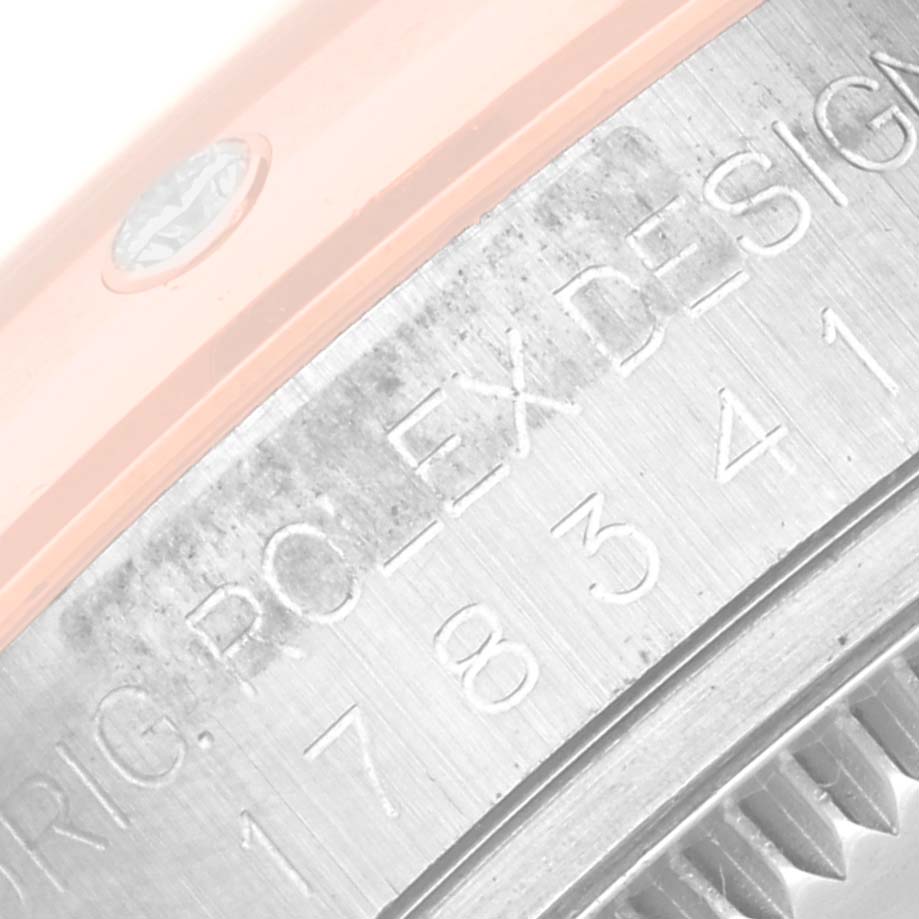 This close-up image shows the inscription on the side of a Rolex Mid-Size 178341 Women's Steel and Gold (two tone) Pink Dial 178341 Women's Steel and Gold (two tone) Pink Dial model watch bezel and part of its fluted edge.