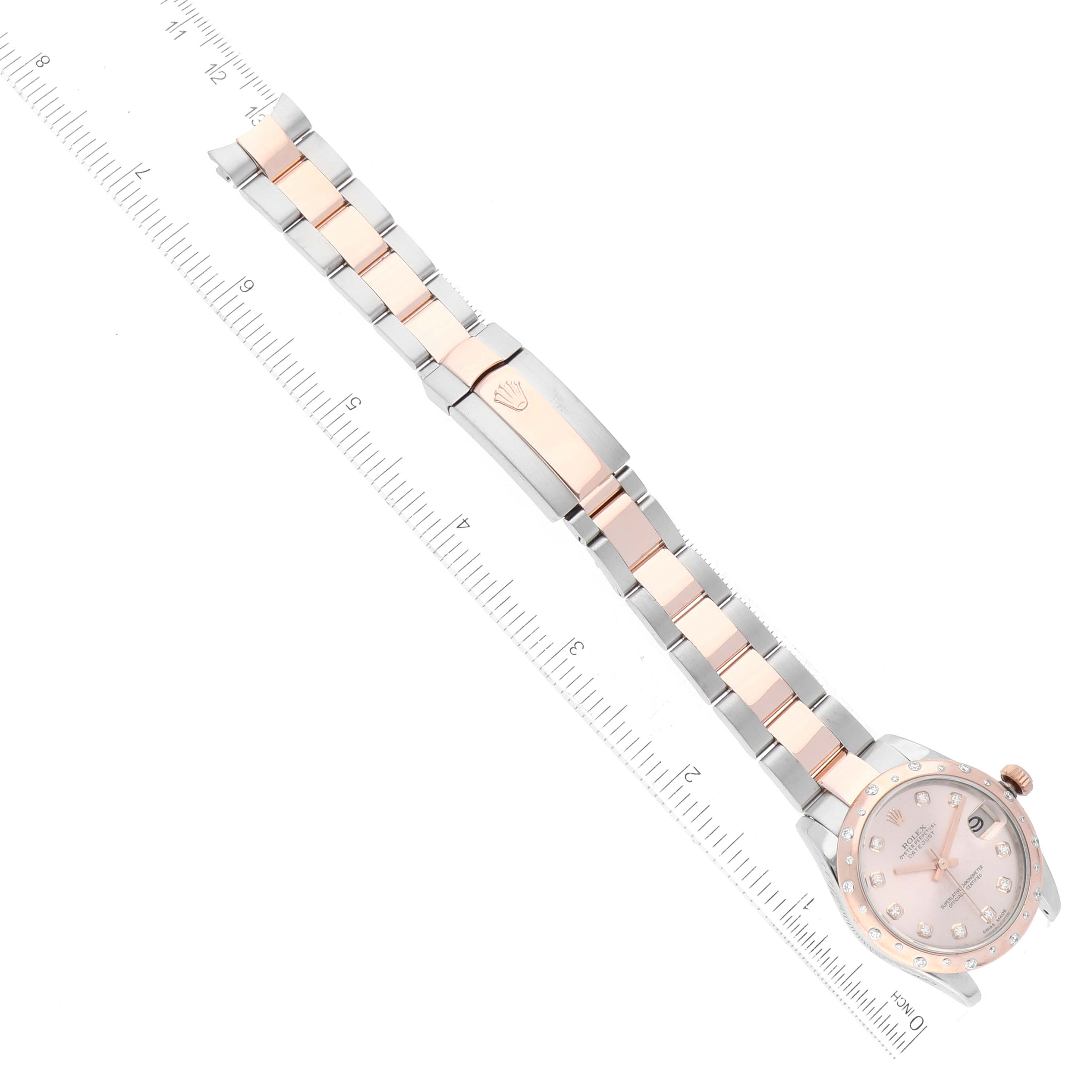 The image shows a full view of the Rolex Mid-Size 178341 Women's Steel and Gold (two tone) Pink Dial 178341 Women's Steel and Gold (two tone) Pink Dial watch, including the face, crown, and entire bracelet with a ruler for scale.