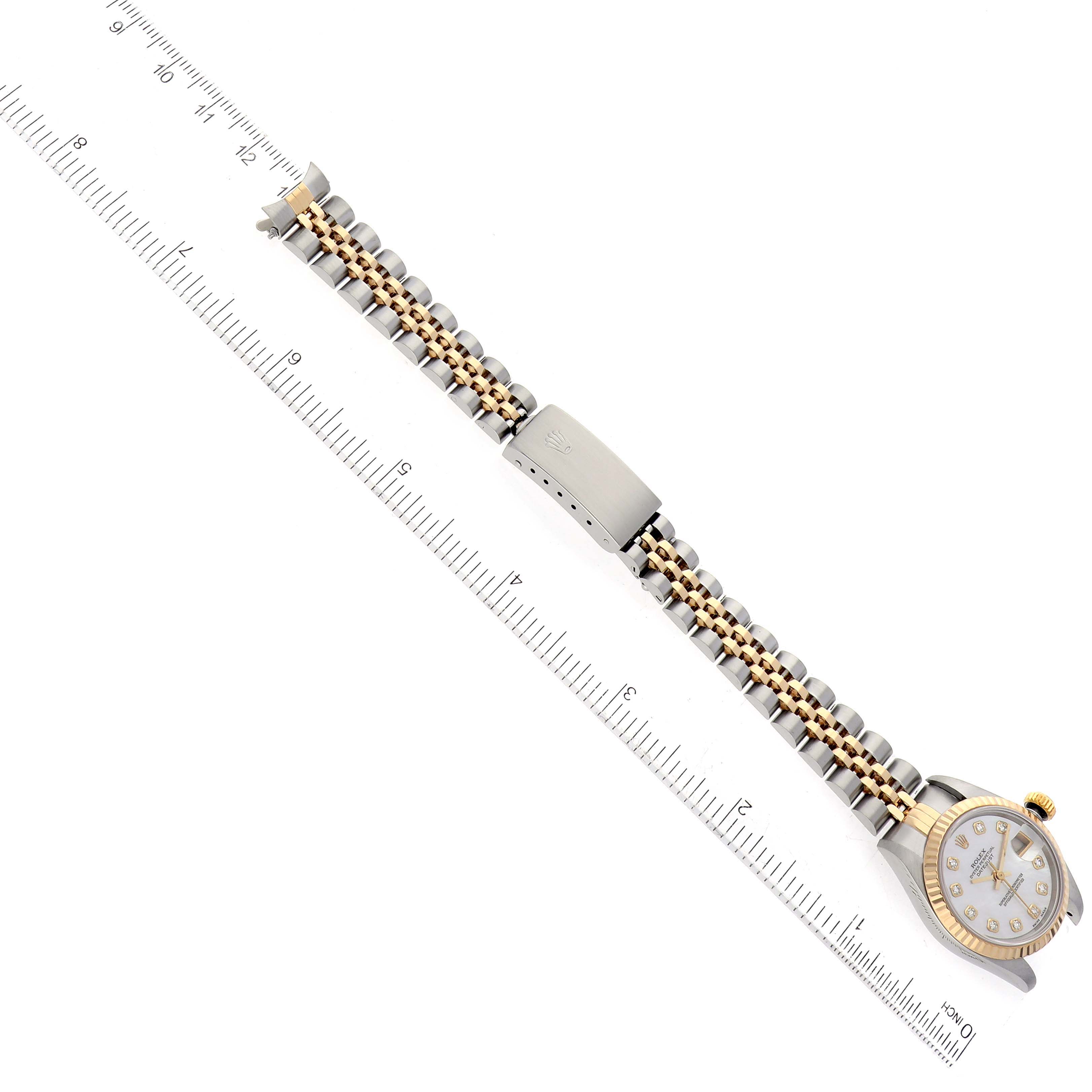 This image shows a Rolex Datejust 69173 Women's Steel and Gold (two tone) Mother of Pearl Dial 69173 Women's Steel and Gold (two tone) Mother of Pearl Dial watch laid flat with a ruler for scale, highlighting the bracelet and clasp.