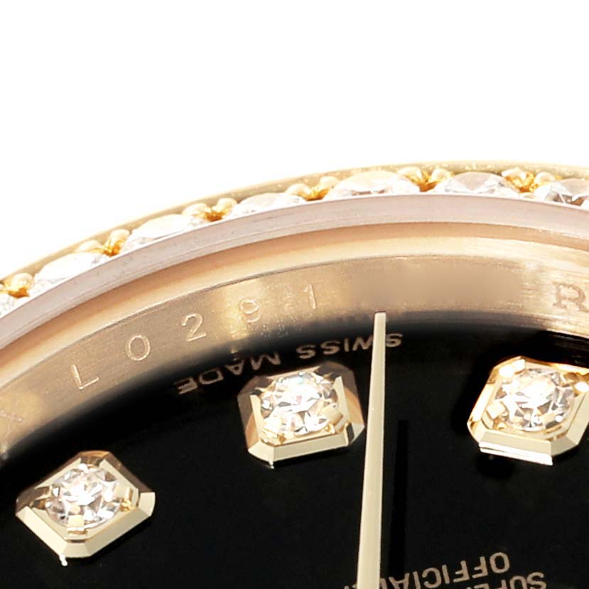 This close-up image of the Rolex President 179138 Women's Yellow Gold Black Dial 179138 Women's Yellow Gold Black Dial model watch shows part of the bejeweled bezel and diamond hour markers.