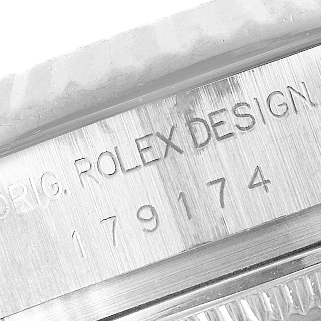 The image shows a close-up of the case side of a Rolex Datejust 179174 Women's Stainless Steel Black Dial 179174 Women's Stainless Steel Black Dial watch with the model number and "ROLEX DESIGN" engraving.