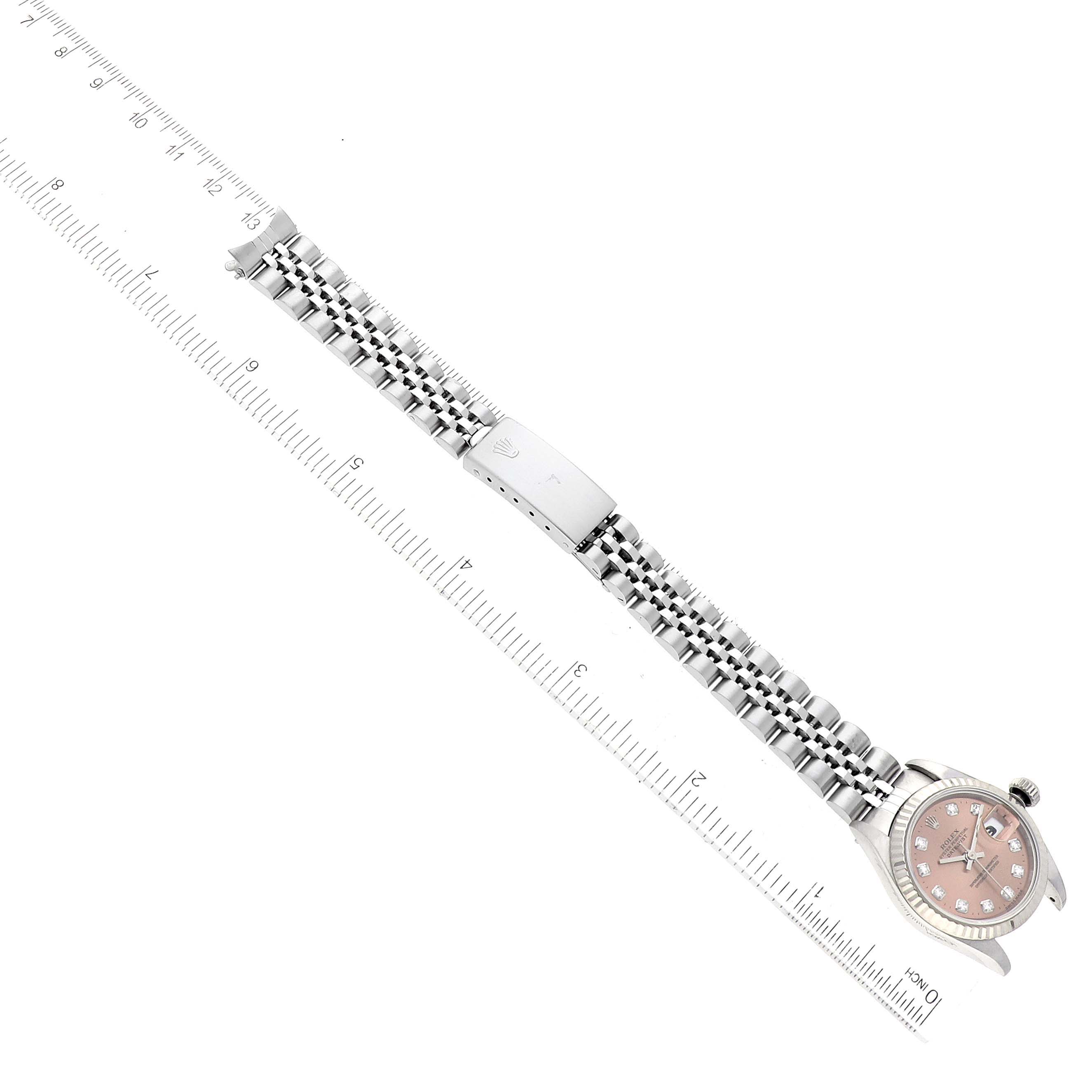 This image shows a Rolex Datejust 69174 Women's Stainless Steel Pink Dial 69174 Women's Stainless Steel Pink Dial watch laid flat with its face, bracelet, and clasp fully visible next to a ruler.