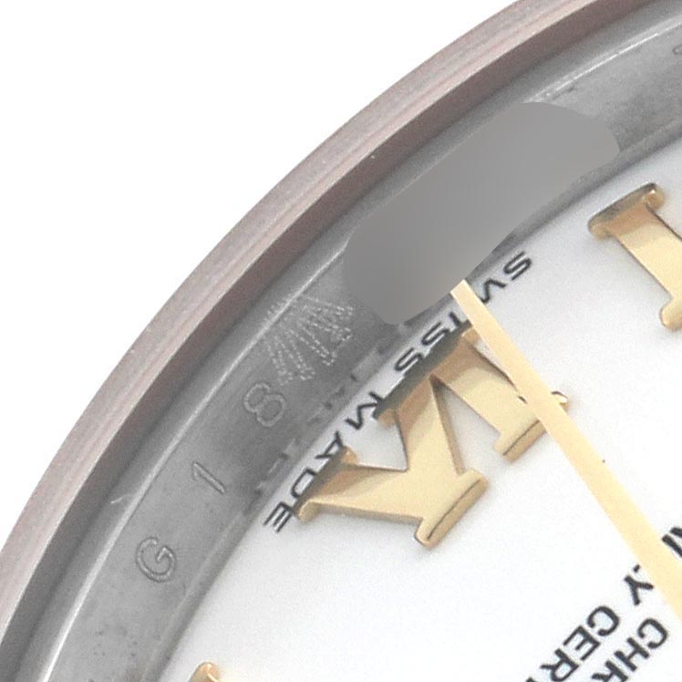 This close-up image shows the edge of a Rolex Datejust 179173 Women's Steel and Gold (two tone) White Dial 179173 Women's Steel and Gold (two tone) White Dial watch face, highlighting the Roman numeral hour marker, part of the dial, and "Swiss Made" text.