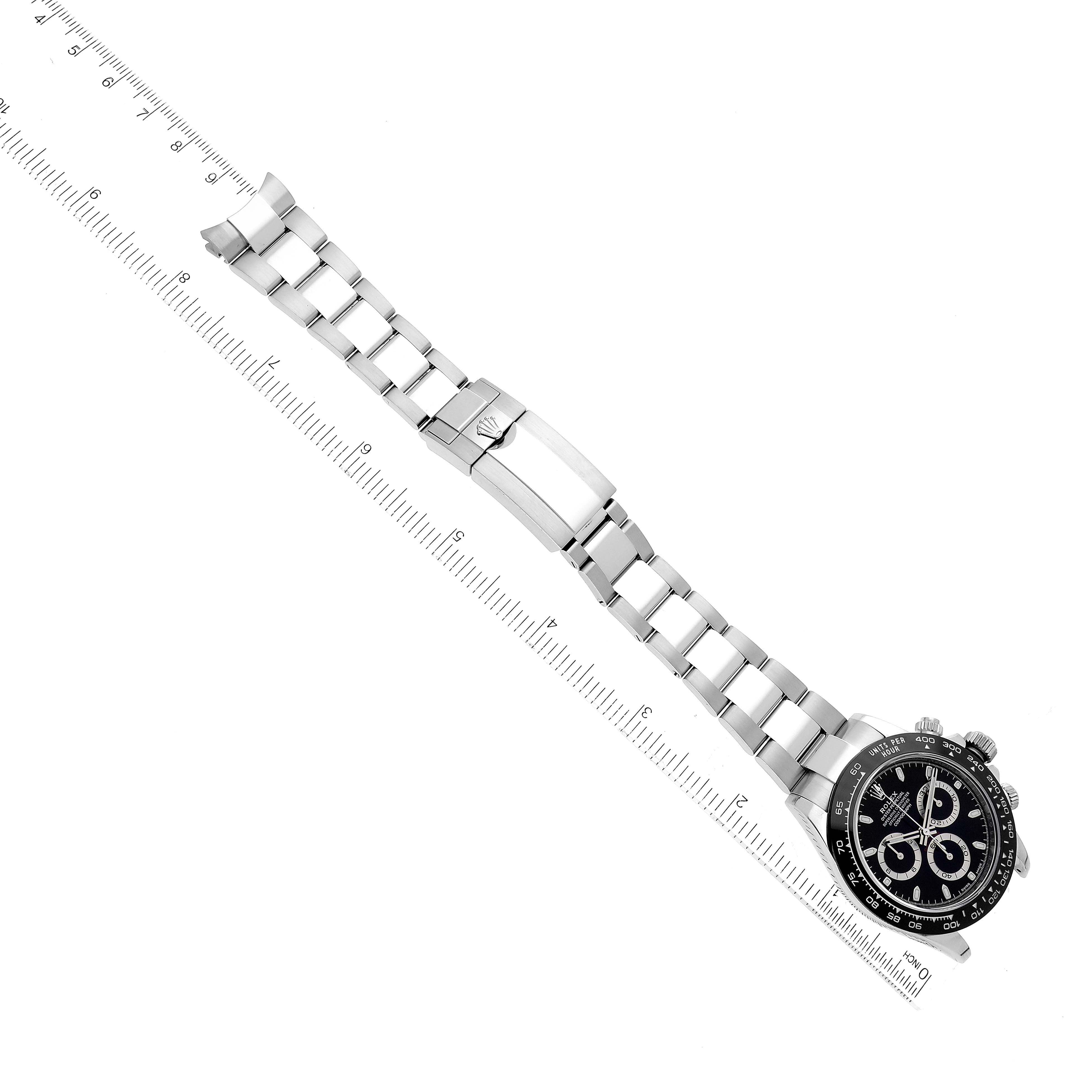 The image shows a Rolex Daytona 116500 Men's Stainless Steel Black Dial 116500 Men's Stainless Steel Black Dial watch laid flat, displaying its bracelet, clasp, and face, with a ruler beside it for scale.