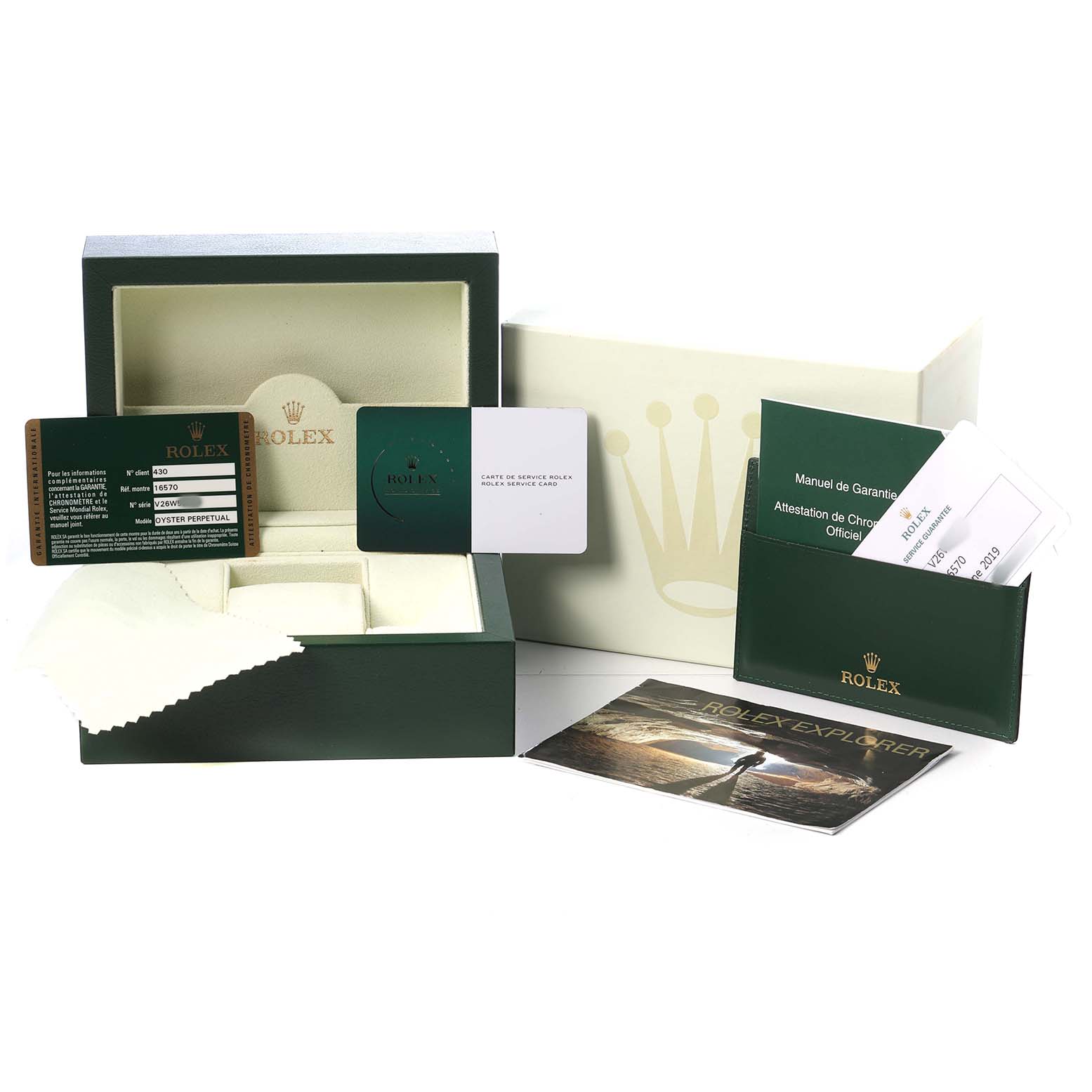 The image shows the open box and accessories of a Rolex Explorer 16570 T Men's Stainless Steel White Dial, including warranty cards and manuals.