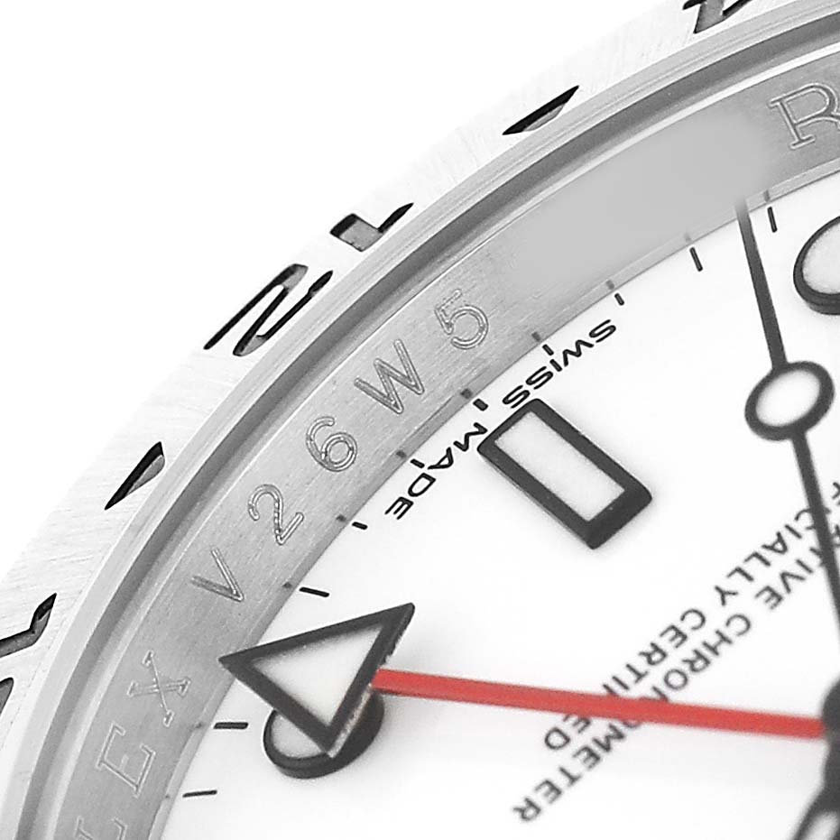 The image shows a close-up of the Rolex Explorer 16570 T Men's Stainless Steel White Dial's dial, bezel, and a red hand, highlighting details and inscriptions.