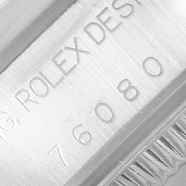 The image shows a close-up of the engraved text and part of the bezel for the Rolex Oyster Perpetual 76080 Women's Stainless Steel White Dial 76080 Women's Stainless Steel White Dial watch.