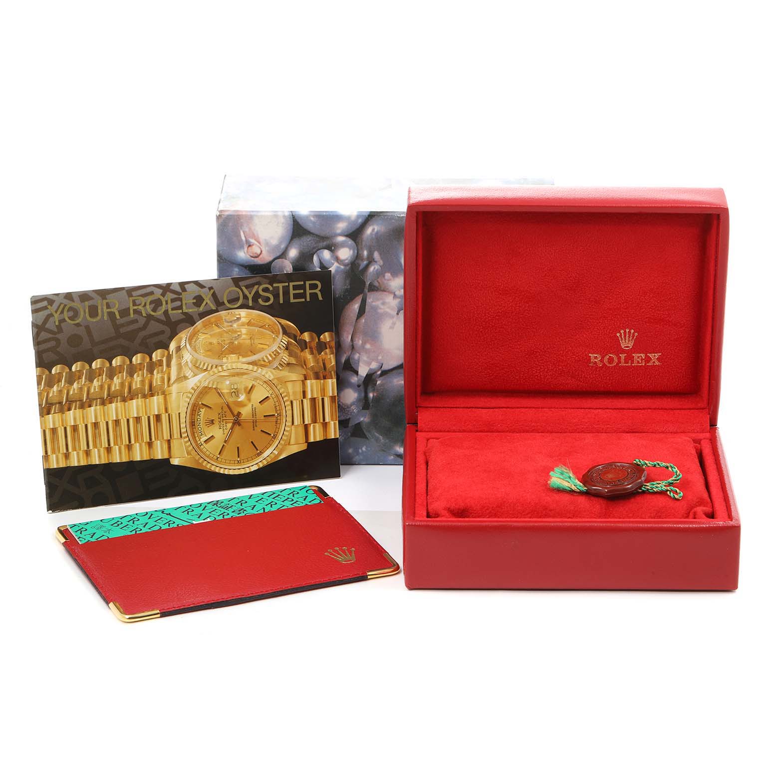 The image shows the packaging, manual, and accessories of a Rolex Oyster Perpetual 76030 Women's Stainless Steel Pink Dial 76030 Women's Stainless Steel Pink Dial, including a red watch box and a tag.