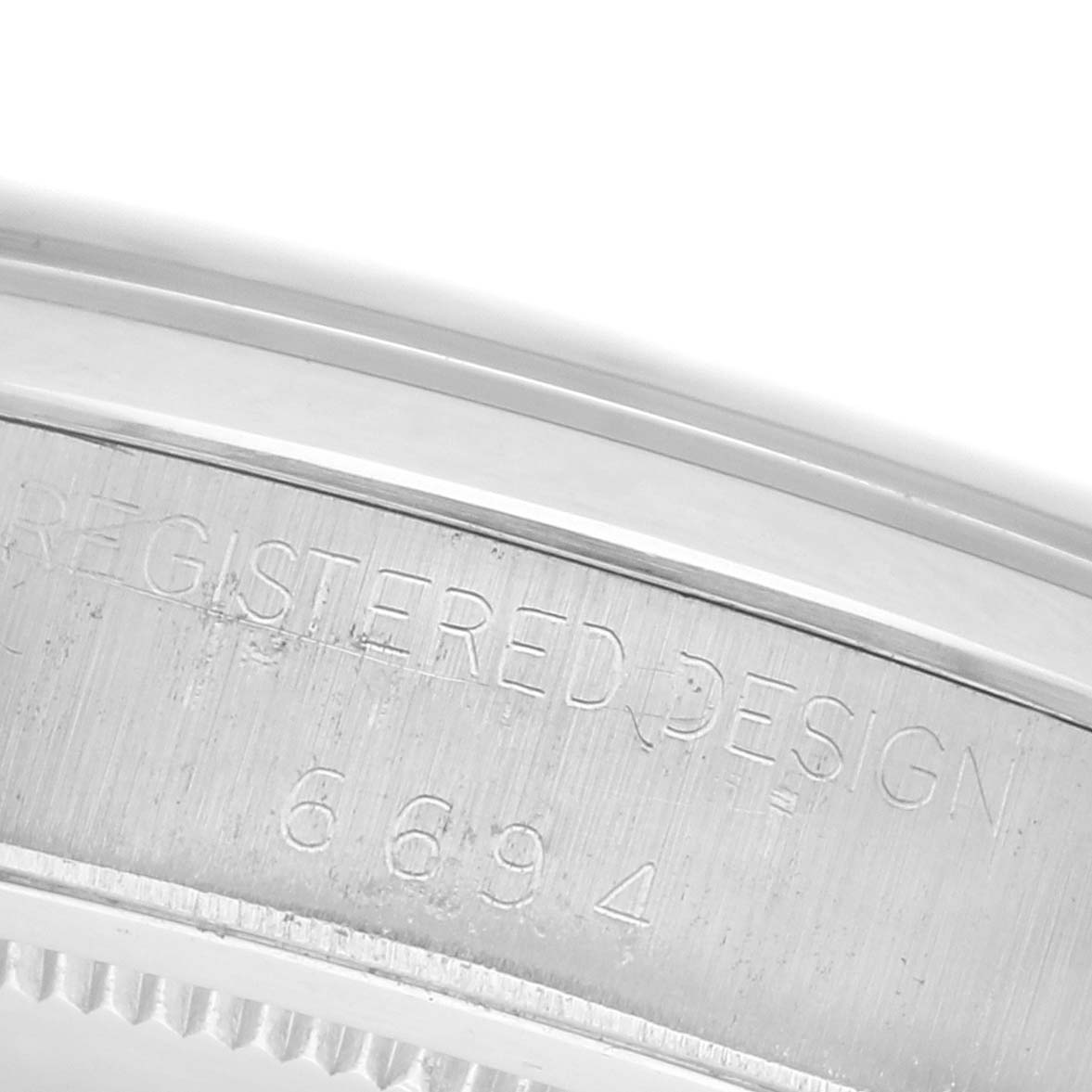 The image shows a close-up of the engraving on the side of the case for the Rolex Date model watch.