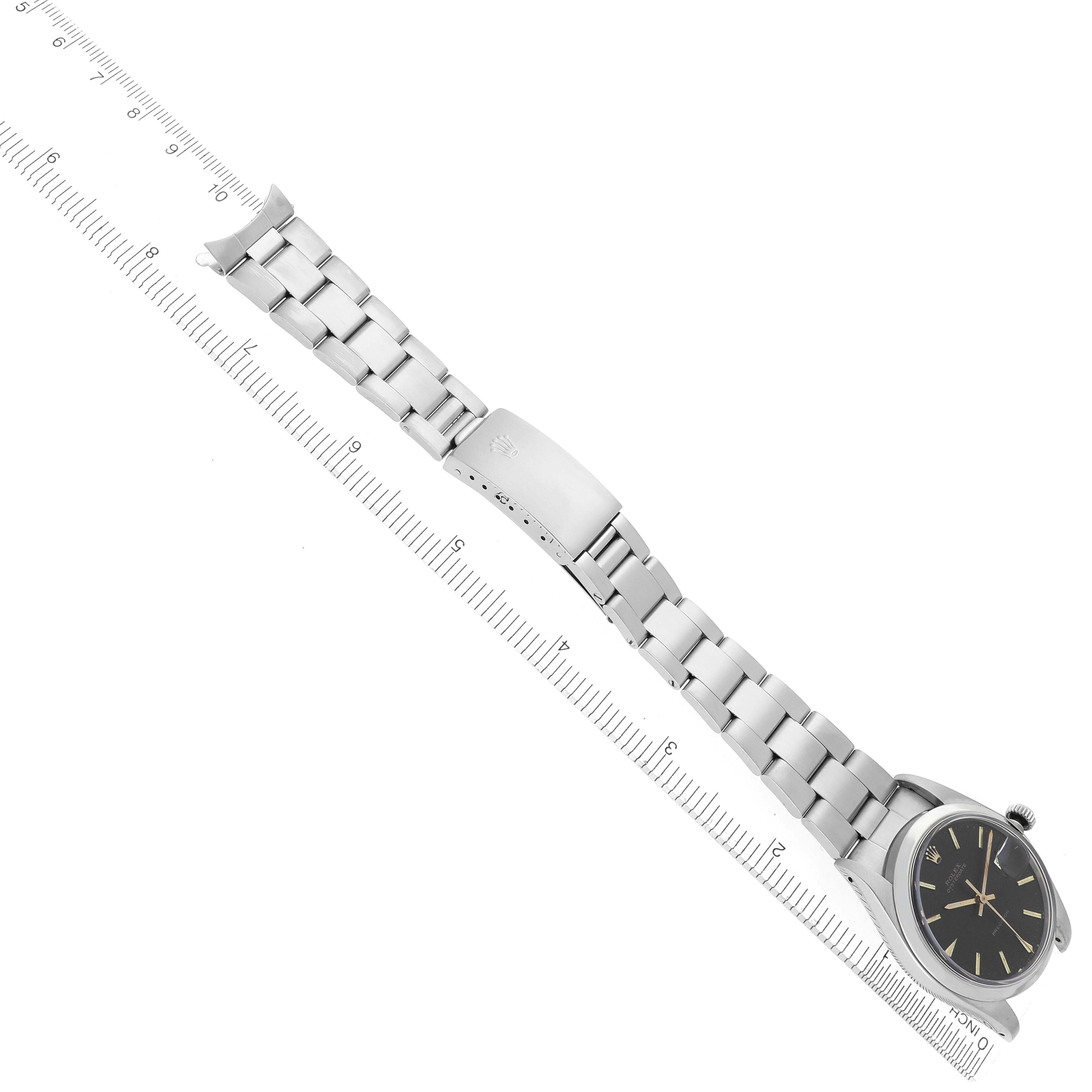 The Rolex Date watch is shown from an angled top view, highlighting the watch head and the full metal bracelet with a clasp.