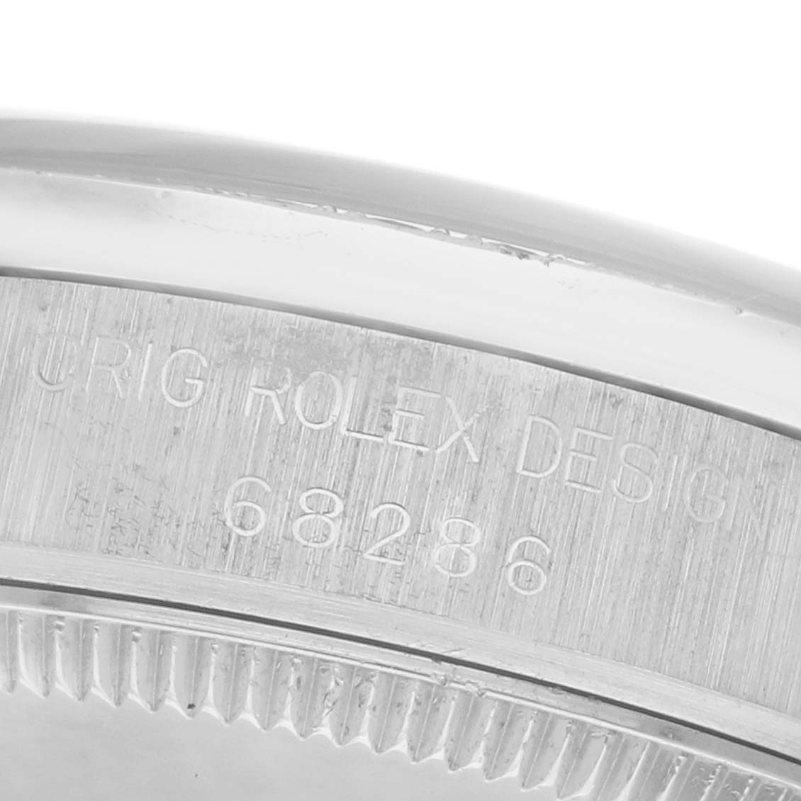 The image shows the side of a Rolex Mid-Size model watch, focusing on the engraved rim with design details.