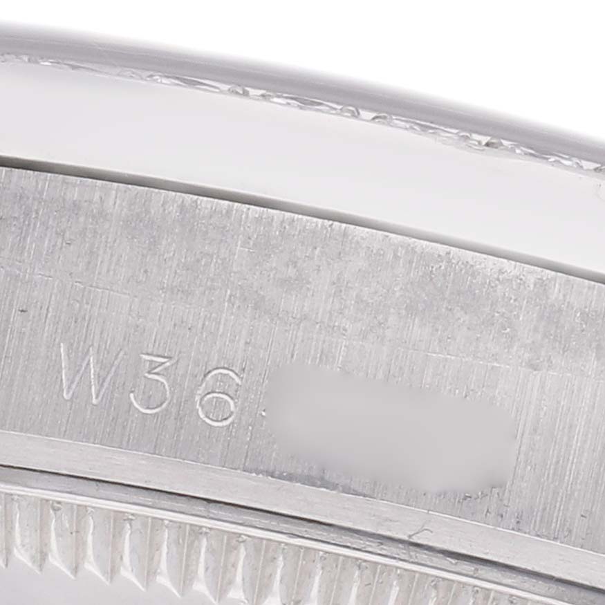 The image shows a close-up of the bezel and part of the engraved serial number on a Rolex Mid-Size model.