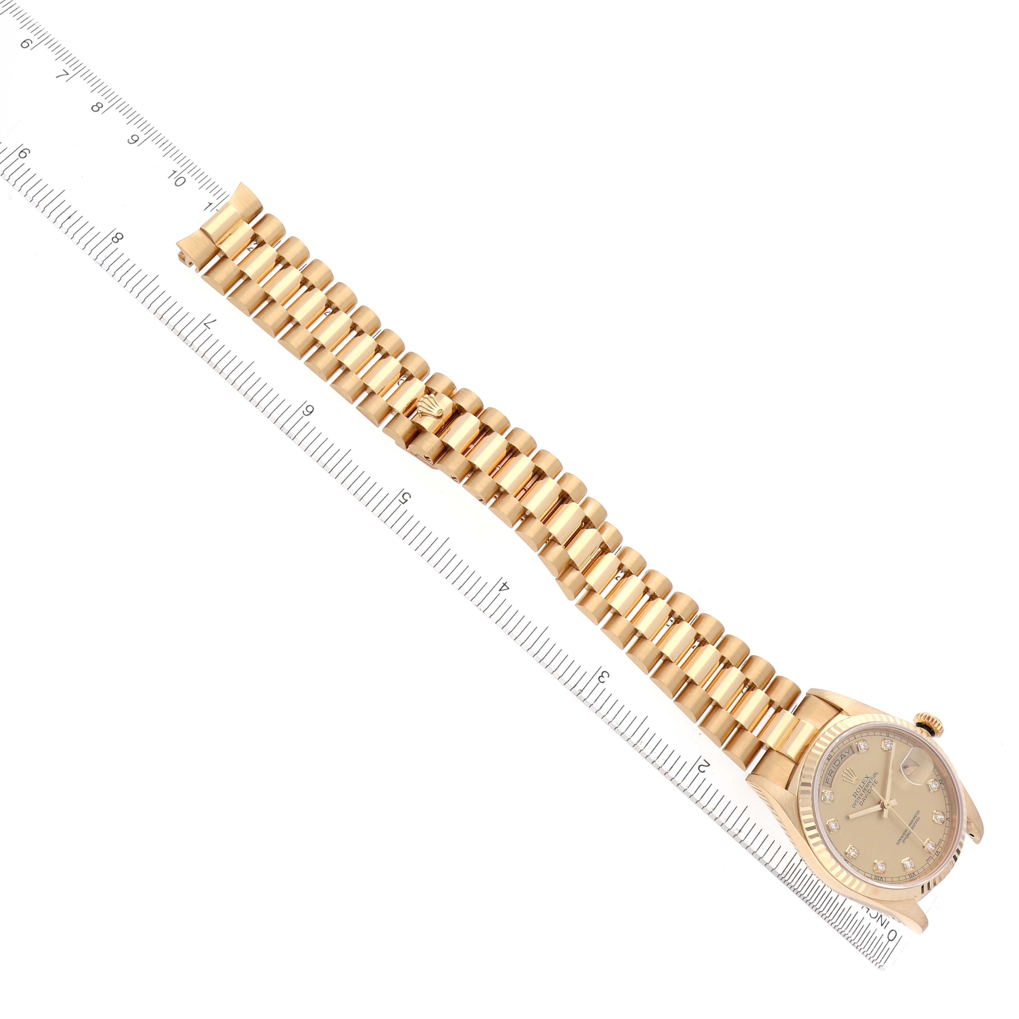 The Rolex President 18238 Men's Yellow Gold Champagne Dial 18238 Men's Yellow Gold Champagne Dial model watch is shown from the front, featuring the case, dial, and entire bracelet next to a ruler.