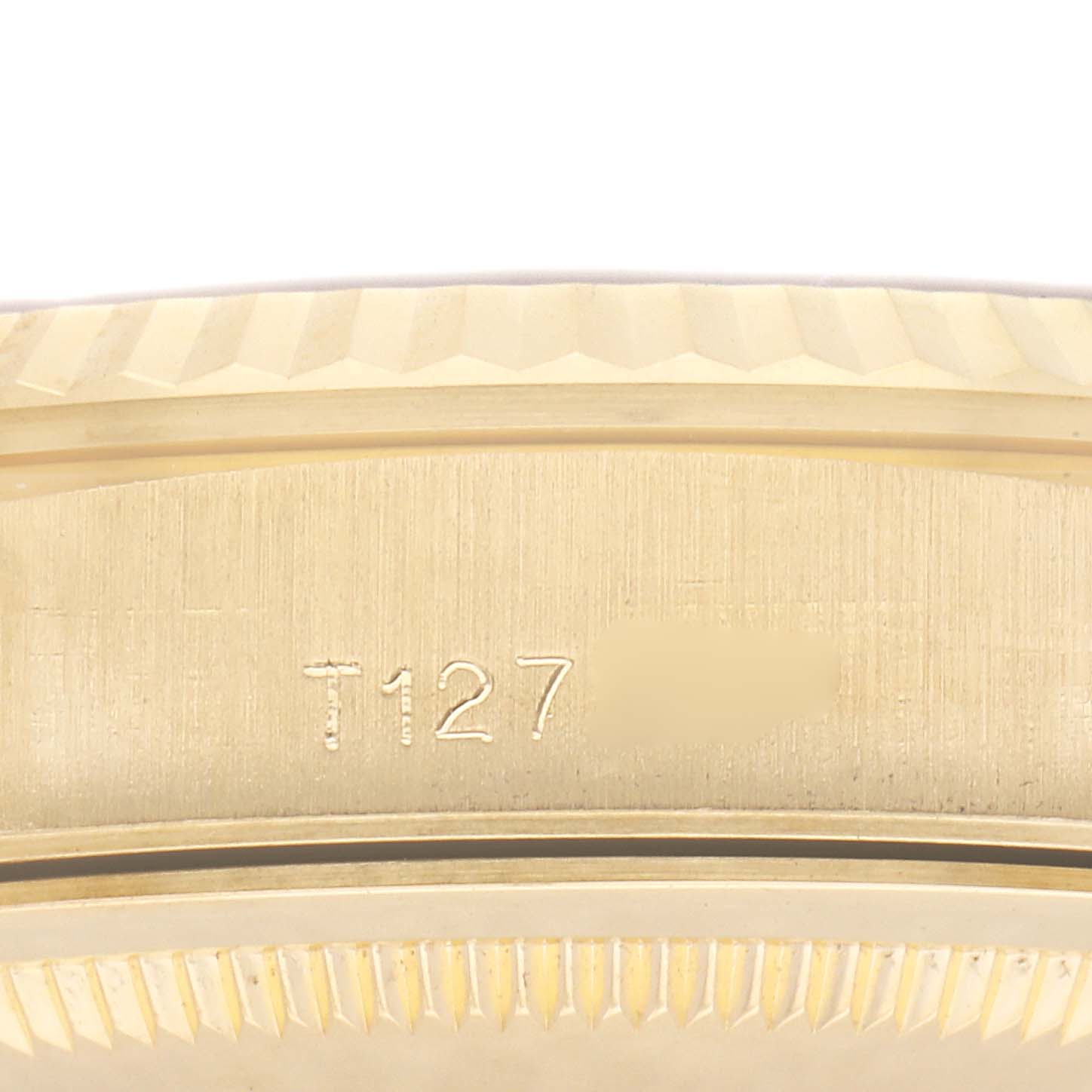 The image shows a close-up of the side of a Rolex President 18238 Men
s Yellow Gold Champagne Dial 18238 Men
s Yellow Gold Champagne Dial watch, highlighting the engraved serial number and fluted bezel.