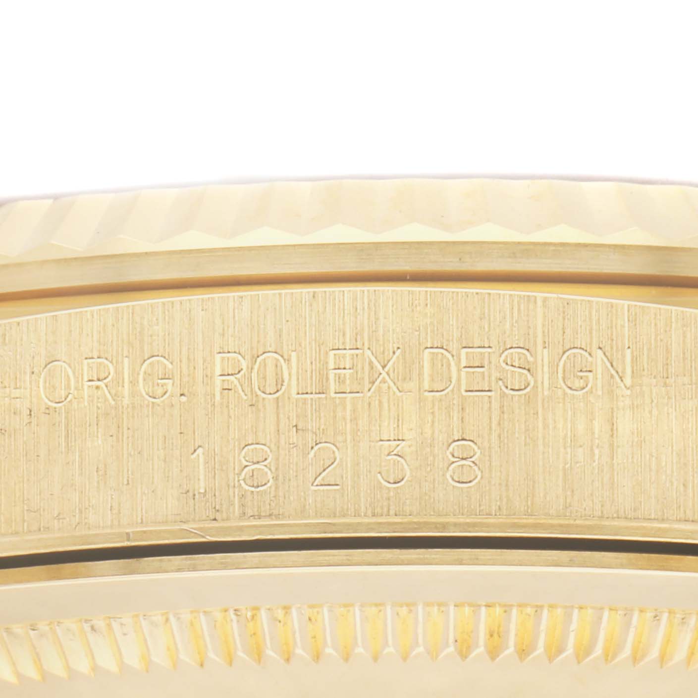 The image shows a close-up of the side engraving of a Rolex President 18238 Men
s Yellow Gold Champagne Dial 18238 Men
s Yellow Gold Champagne Dial model, displaying "ORIG ROLEX DESIGN 18238" on the case.