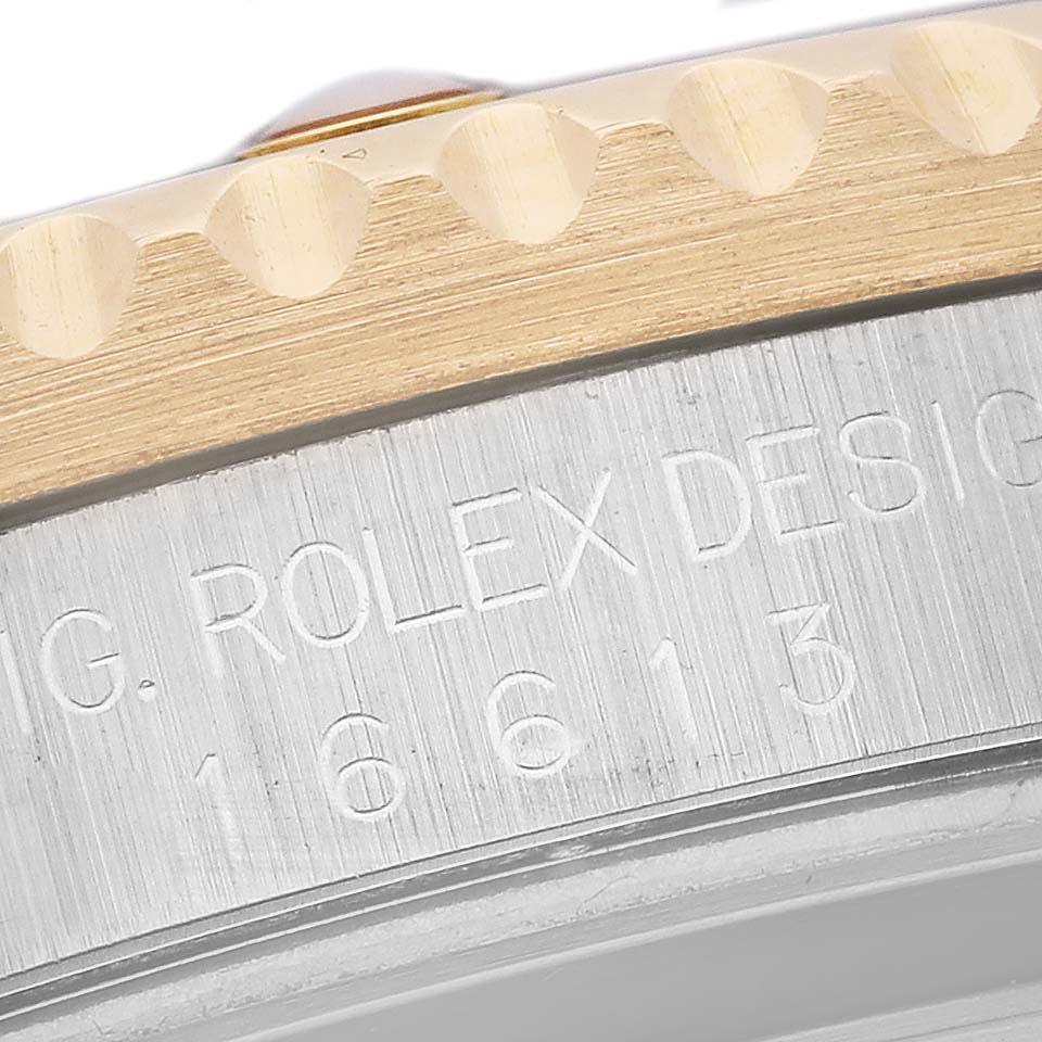 This close-up image shows the bezel and part of the case with model number engraving of a Rolex Submariner 16613 Men's Steel and Gold (two tone) Blue Dial 16613 Men's Steel and Gold (two tone) Blue Dial.