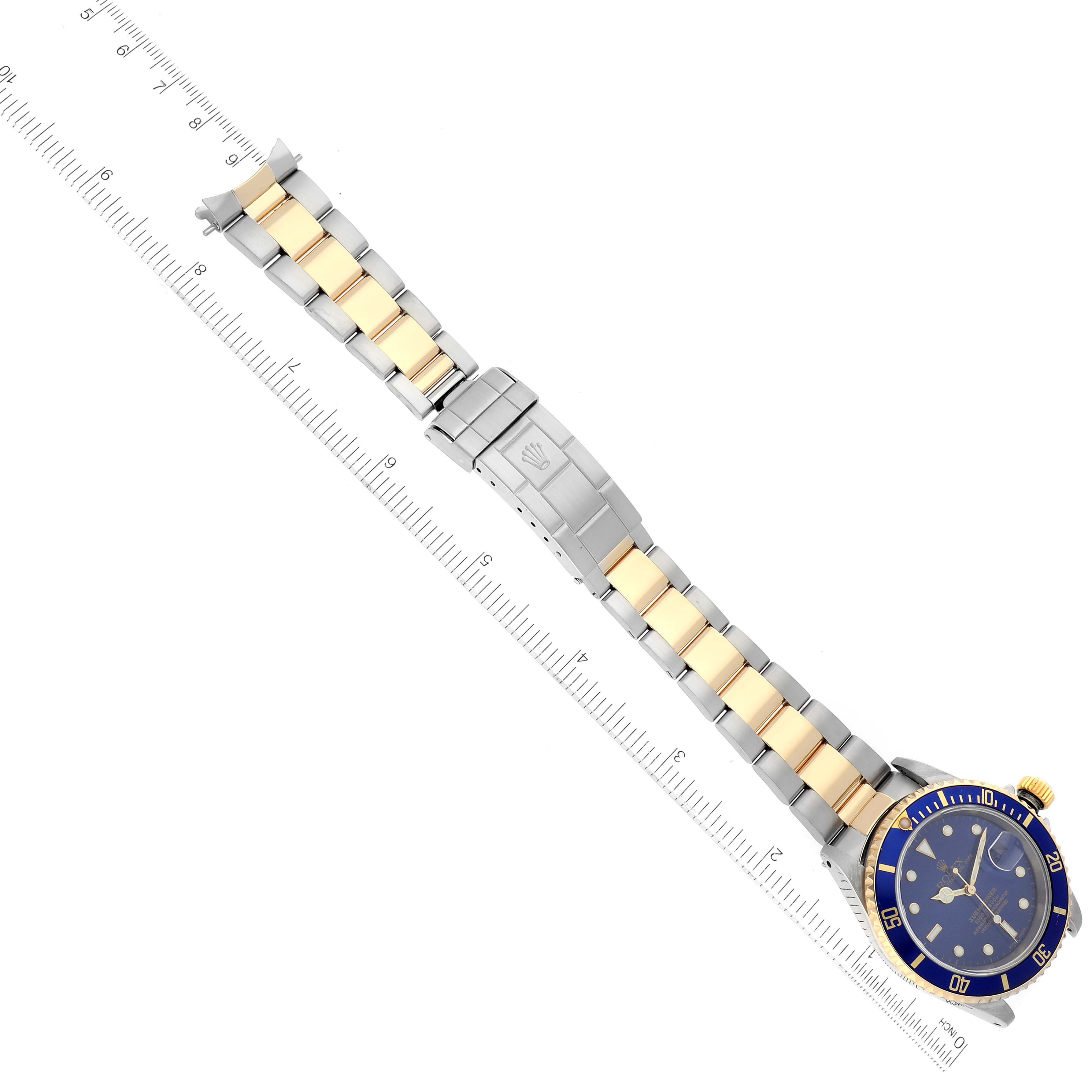 This top-down image shows the entire Rolex Submariner 16613 Men's Steel and Gold (two tone) Blue Dial 16613 Men's Steel and Gold (two tone) Blue Dial watch, including its two-tone bracelet and blue dial.