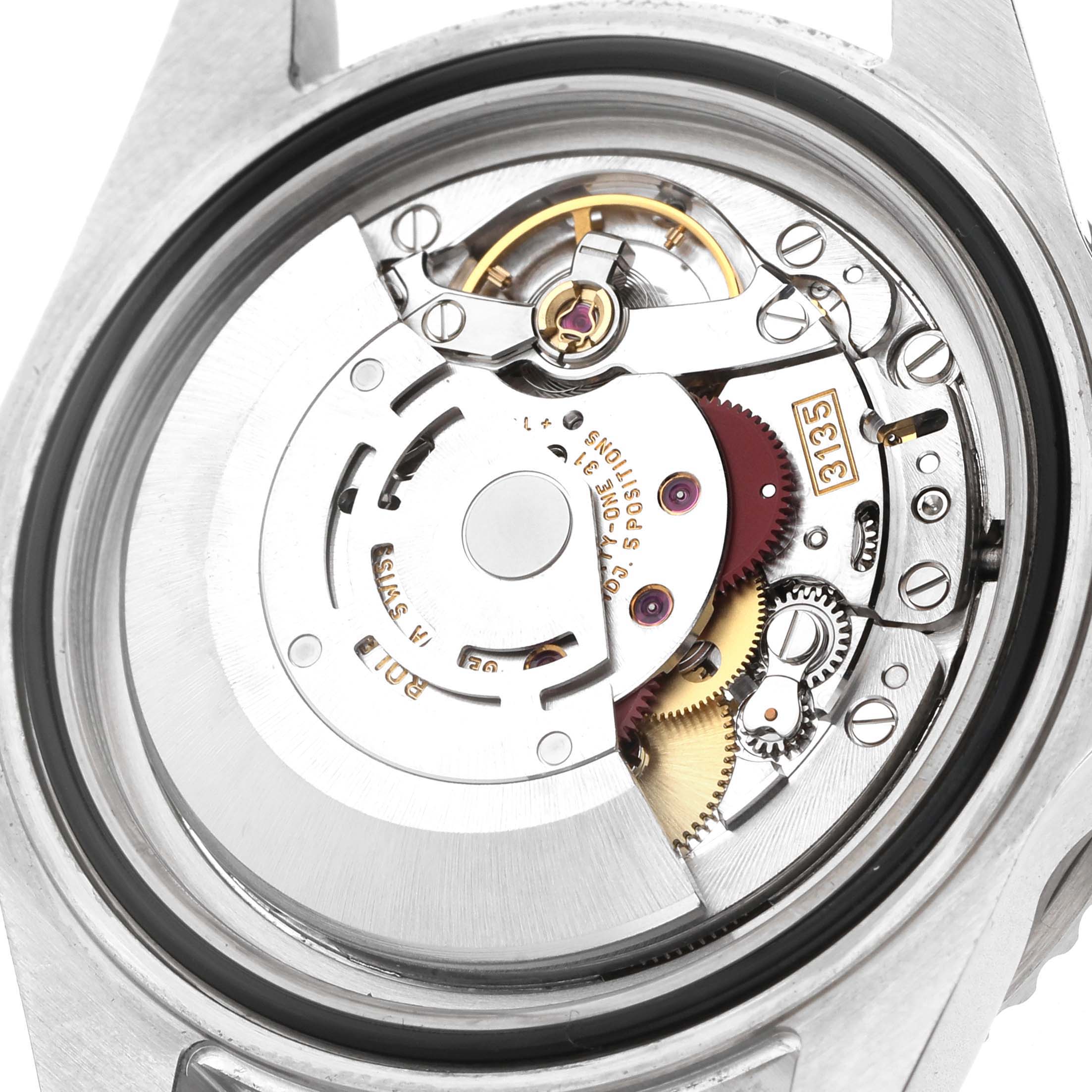 The image shows the back view of a Rolex Submariner 16610 T Men's Stainless Steel Black Dial, highlighting its movement and internal mechanisms.