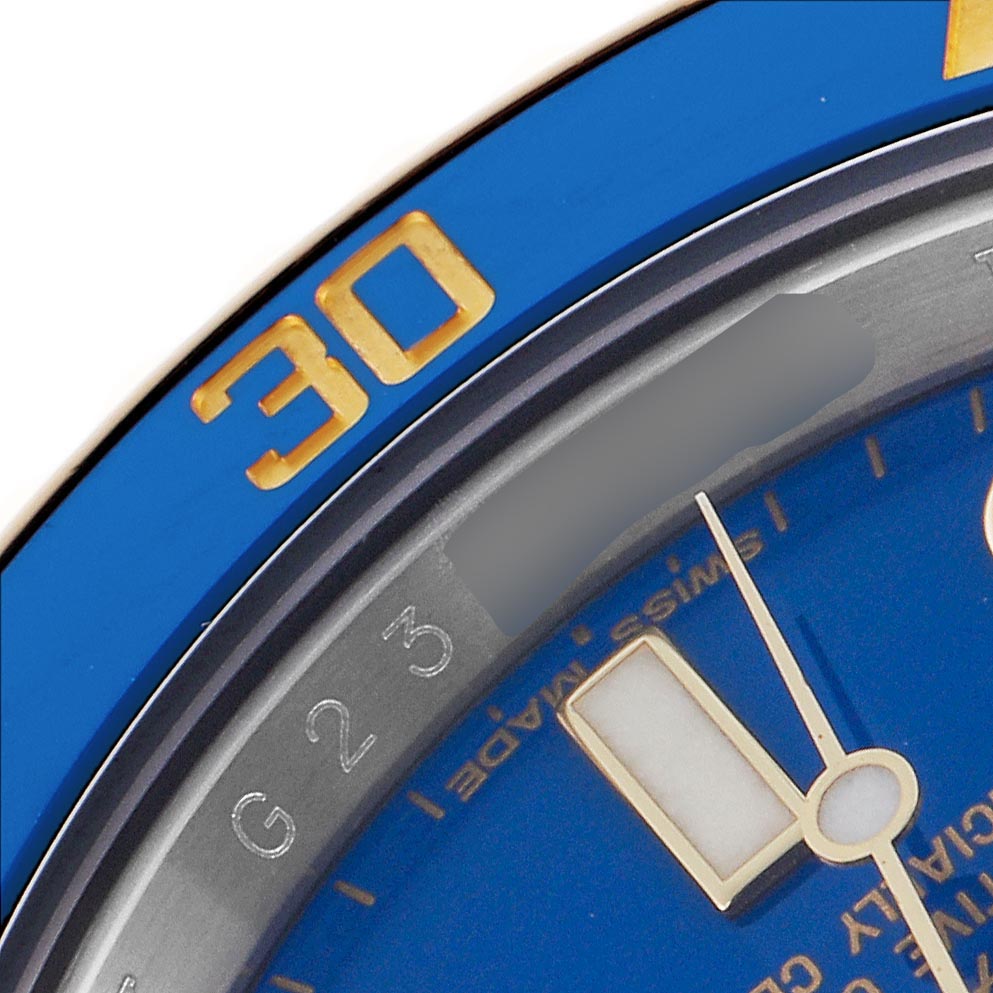 The image shows a close-up of a blue bezel and dial of a Rolex Submariner 116613 Men
s Steel and Gold (two tone) Blue Dial 116613 Men
s Steel and Gold (two tone) Blue Dial, focusing on the 30-minute marker and part of the hour hand.
