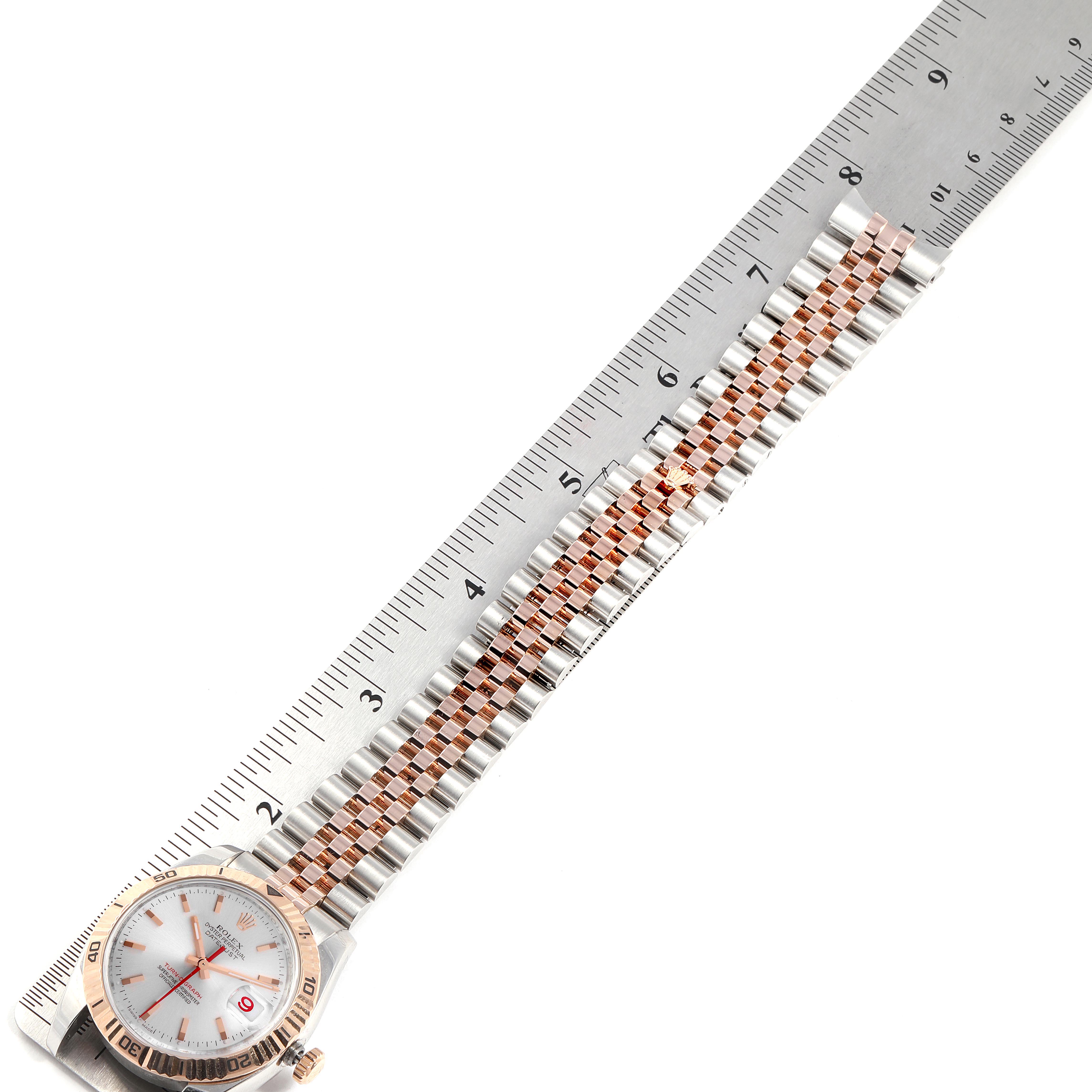 The image shows a Rolex Turn-o-Graph 116261 Men
s Steel and Gold (two tone) Silver Dial 116261 Men
s Steel and Gold (two tone) Silver Dial watch with its band and part of the face, measured against a ruler.