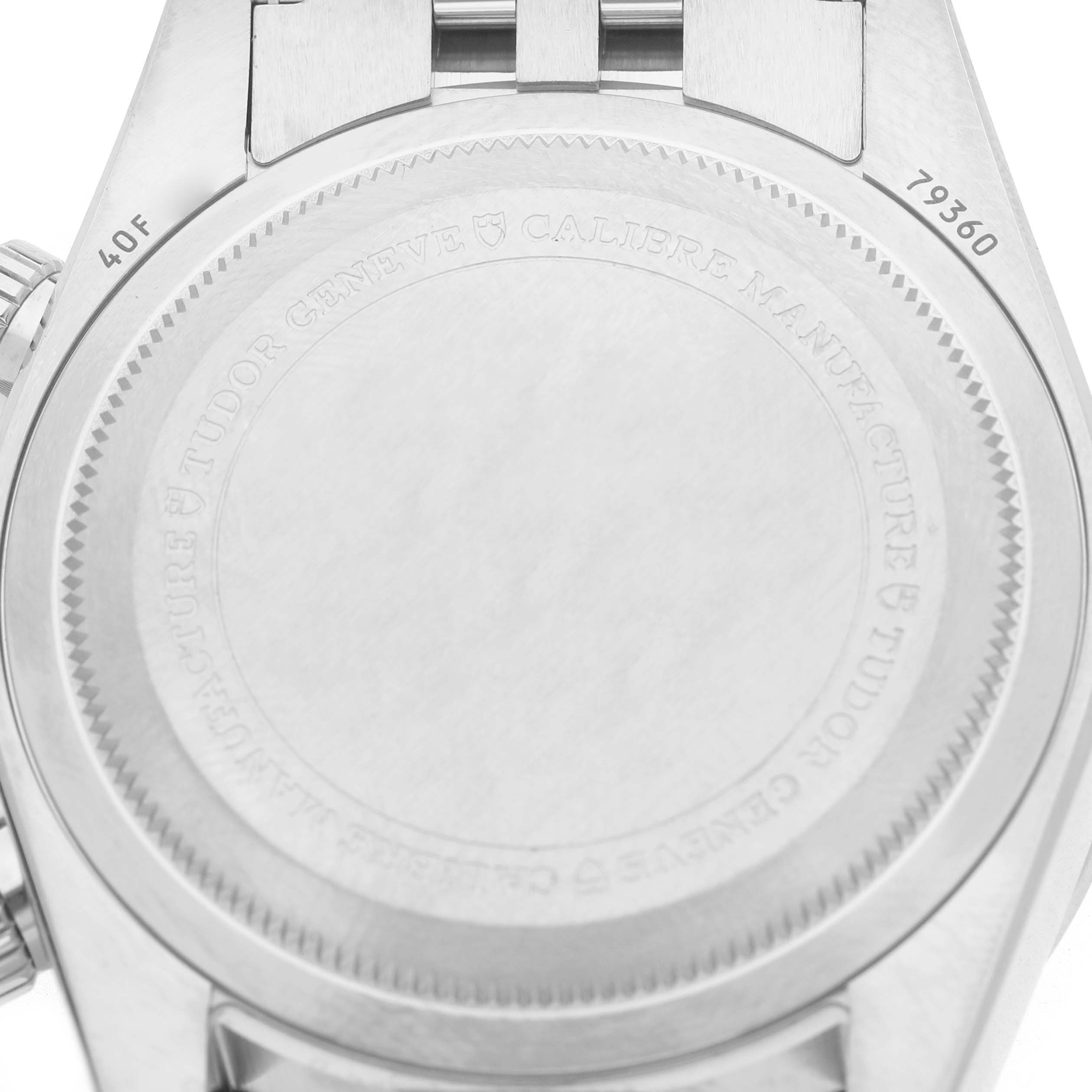 The image shows the back case of a Tudor Heritage Chrono M79360B-0002 Men's Stainless Steel Blue Dial watch, featuring engraved details and a portion of the bracelet.