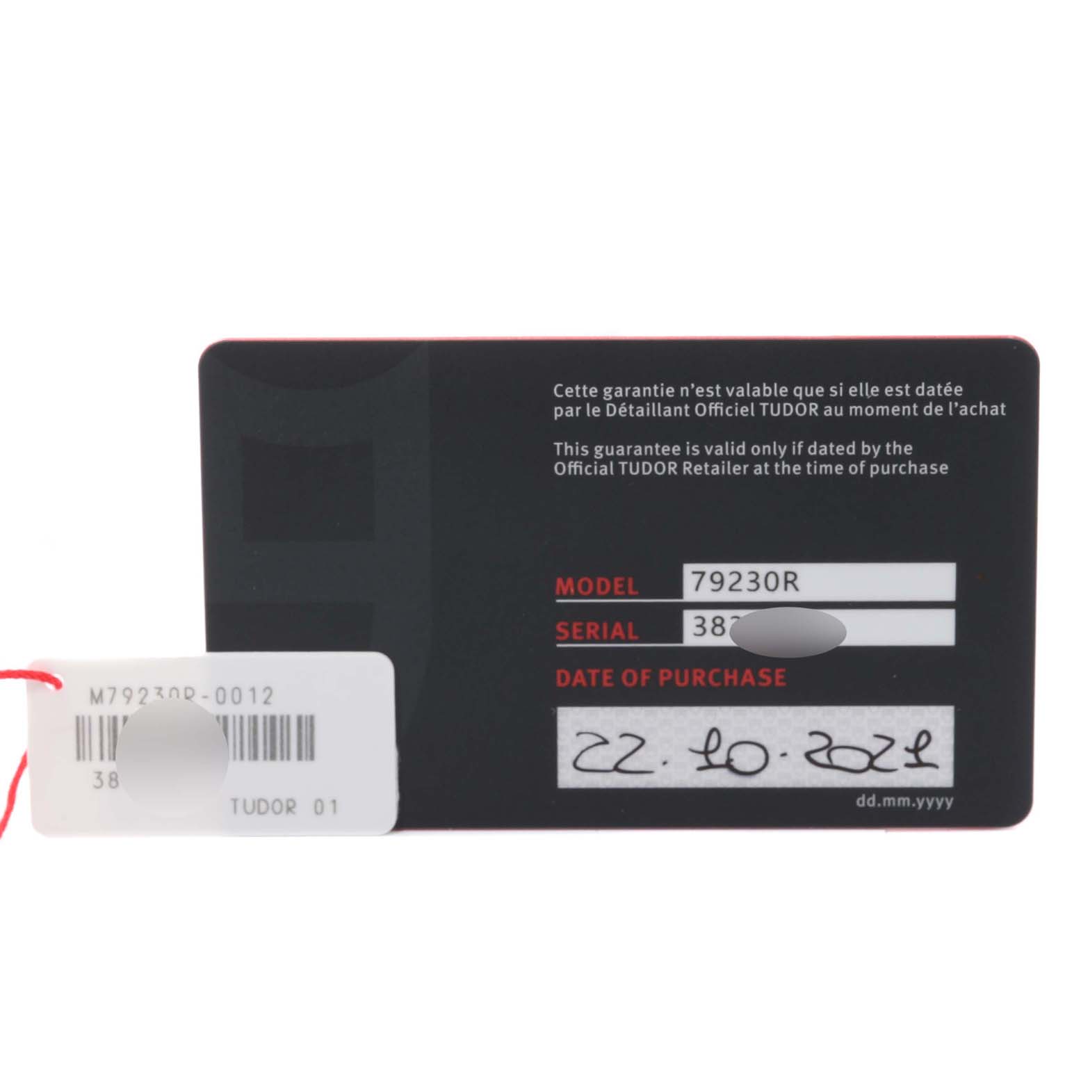 This image shows the warranty card and a tag for the Tudor Heritage Black Bay 79230R Men's Stainless Steel Black Dial 79230R Men's Stainless Steel Black Dial model, displaying the model, serial number, and date of purchase.