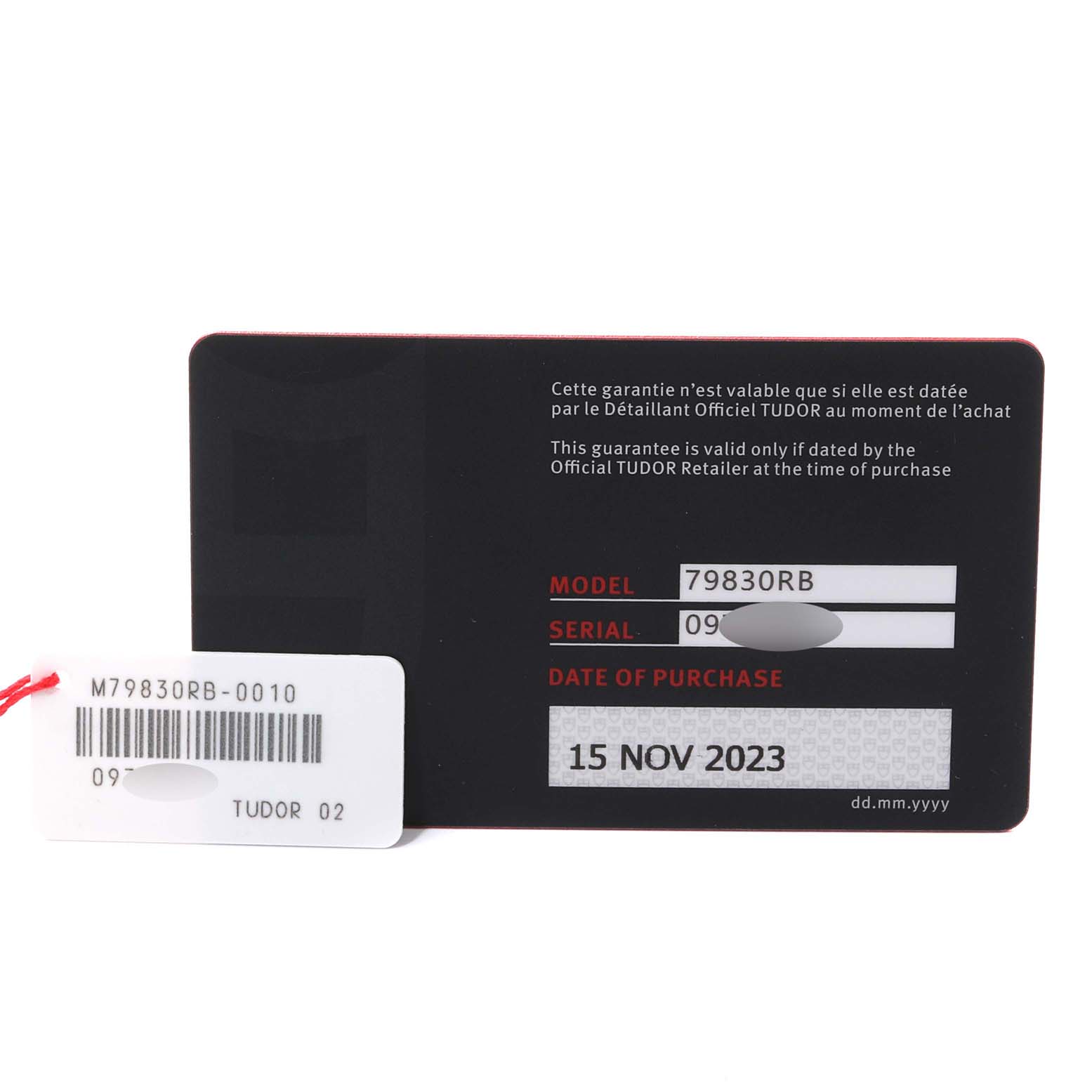 The image shows a close-up of the Heritage Black Bay model by Tudor's warranty card and tag with model and serial number information.