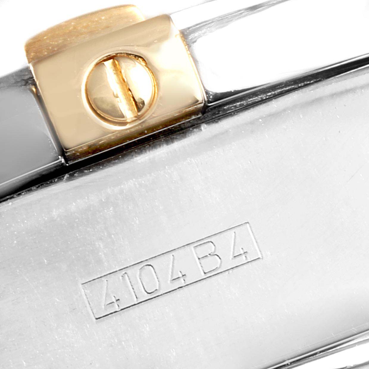 The image shows a close-up view of a clasp on a Breitling Chronomat B13356 Men
s Steel and Gold (two tone) Black Dial B13356 Men
s Steel and Gold (two tone) Black Dial watch with a visible screw and part of the serial number "4104B4".