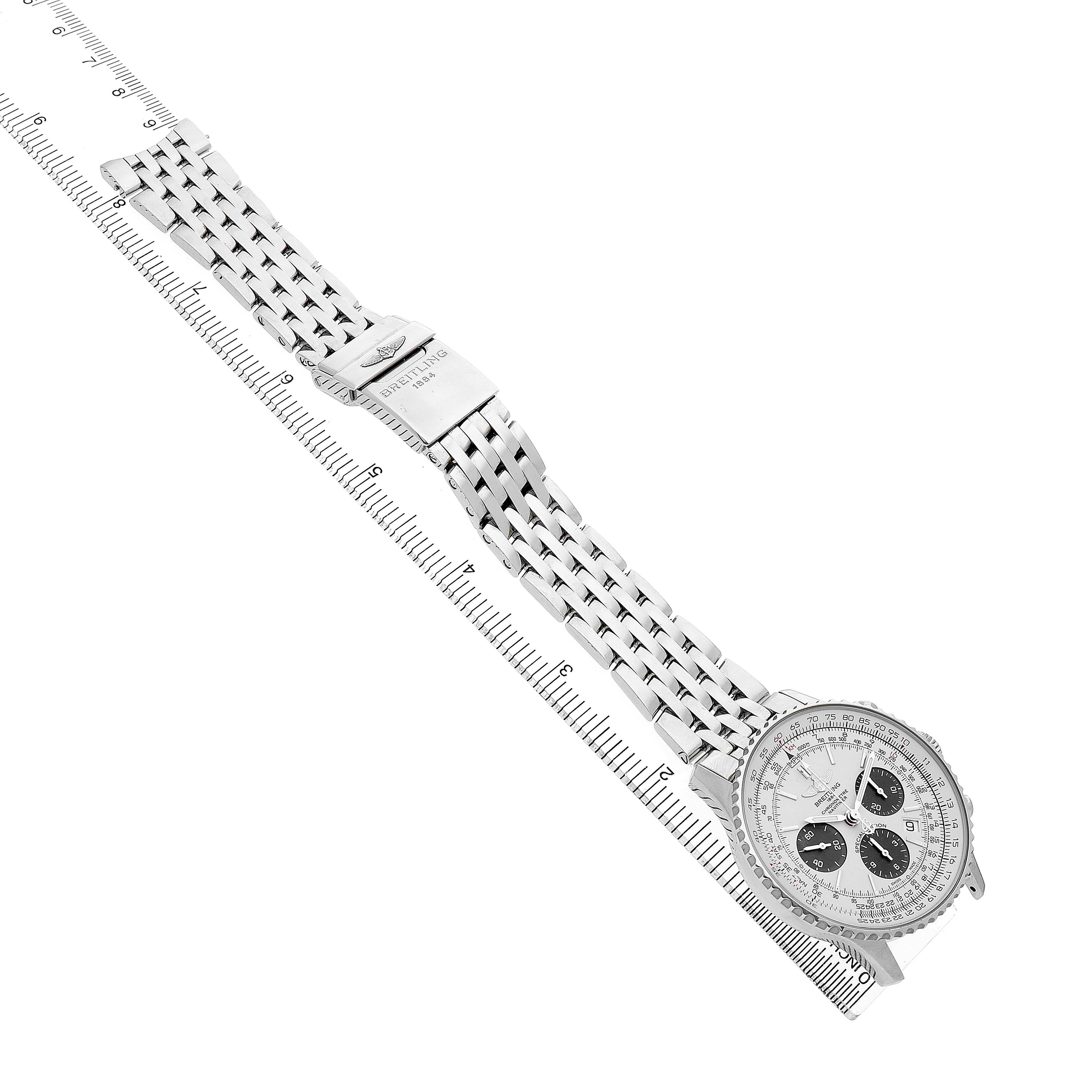 The Breitling Navitimer AB012012/G826 Men's Stainless Steel Silver Dial watch is shown at an angle displaying its face, dial, and metal bracelet, laid flat beside a ruler.