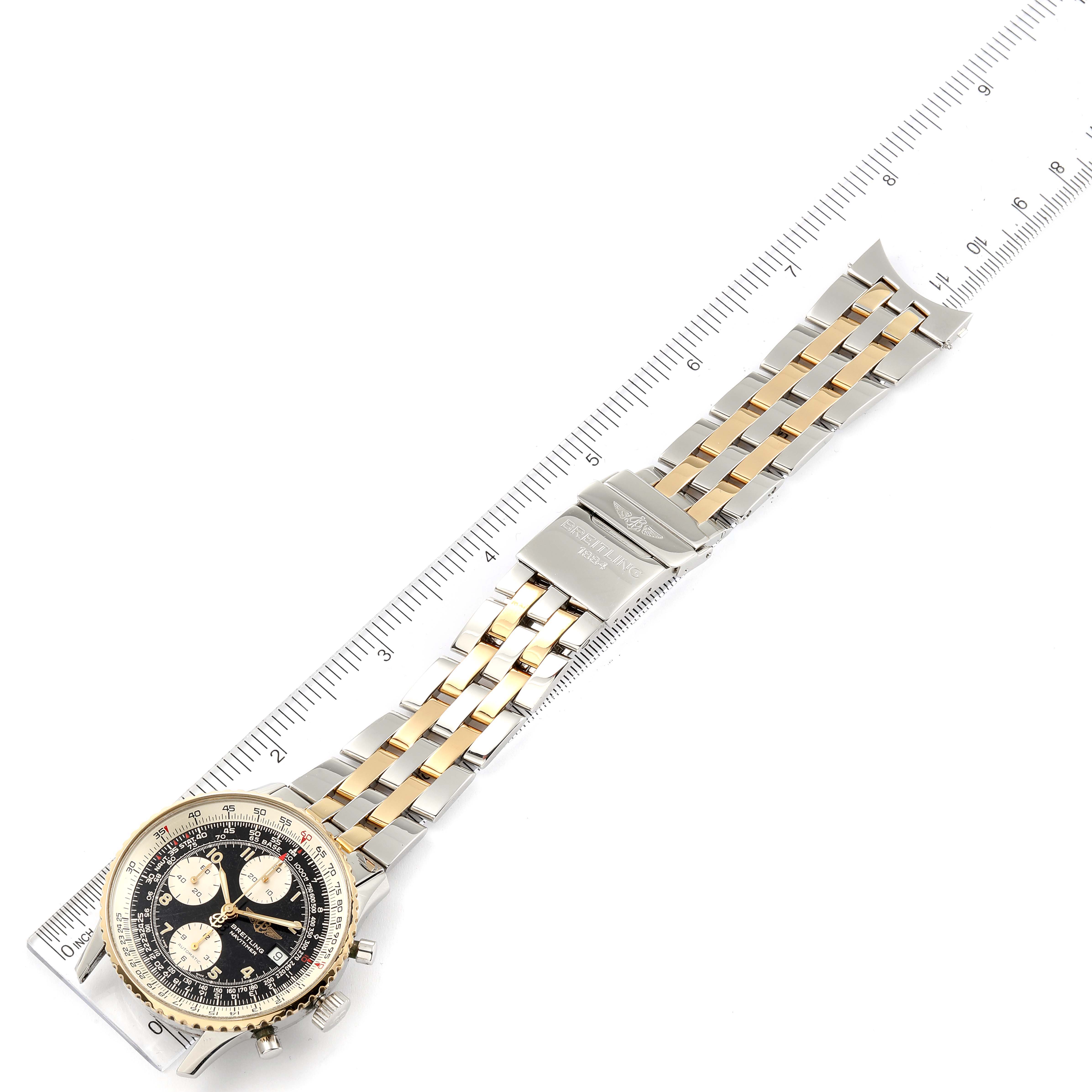 The image shows a Breitling Navitimer B13019 Men's Steel and Gold (two tone) Black Dial B13019 Men's Steel and Gold (two tone) Black Dial watch laid flat with its face and two-tone bracelet visible, alongside a ruler for scale.
