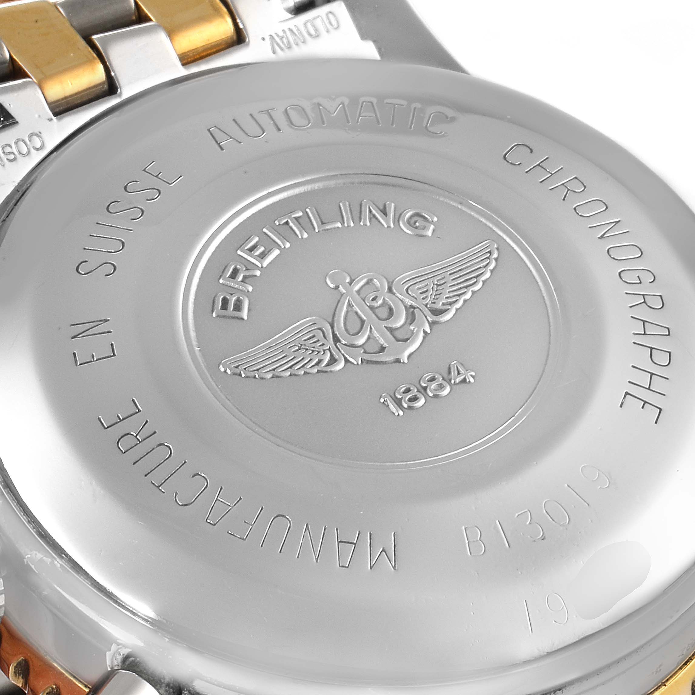 The image shows the case back of a Breitling Navitimer B13019 Men's Steel and Gold (two tone) Black Dial B13019 Men's Steel and Gold (two tone) Black Dial watch from a slightly tilted angle.