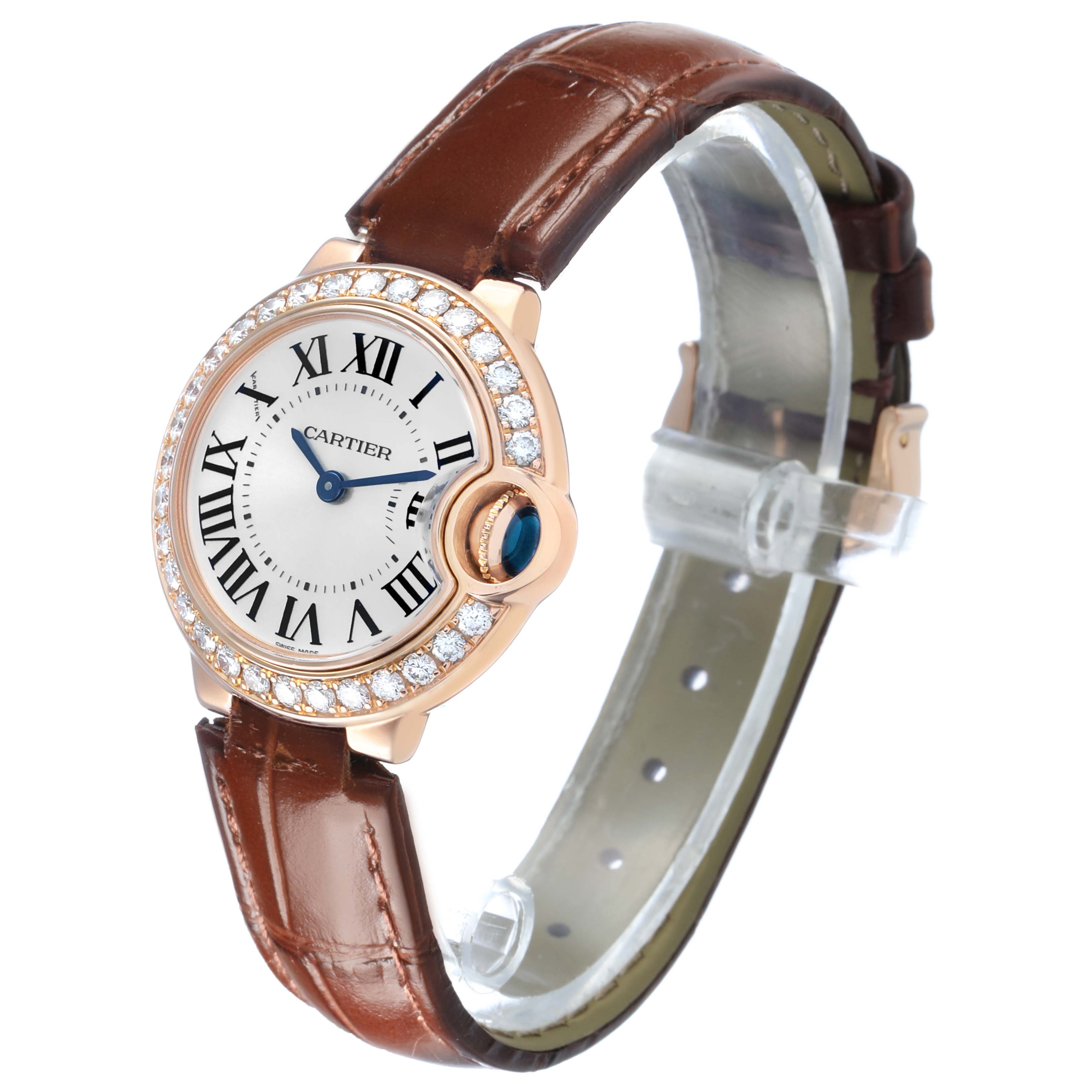 The Cartier Ballon Bleu WE900251 Women's Rose Gold Silver Dial watch is shown at a slight angle, highlighting the watch face, diamond bezel, and leather strap.