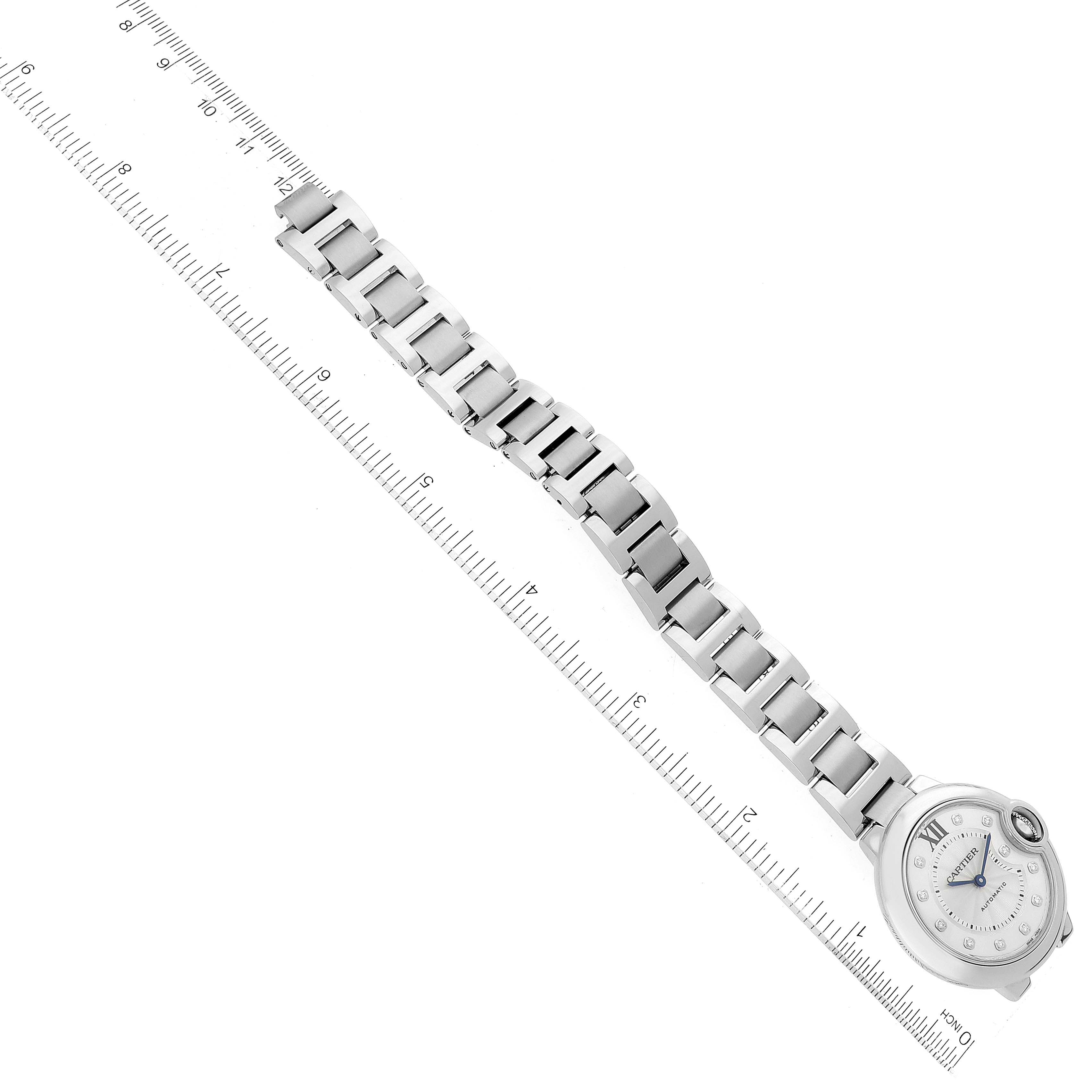 The image shows a top-down view of a Ballon Bleu watch by Cartier, focusing on the entire watch including the bracelet and face, with a ruler beside it.