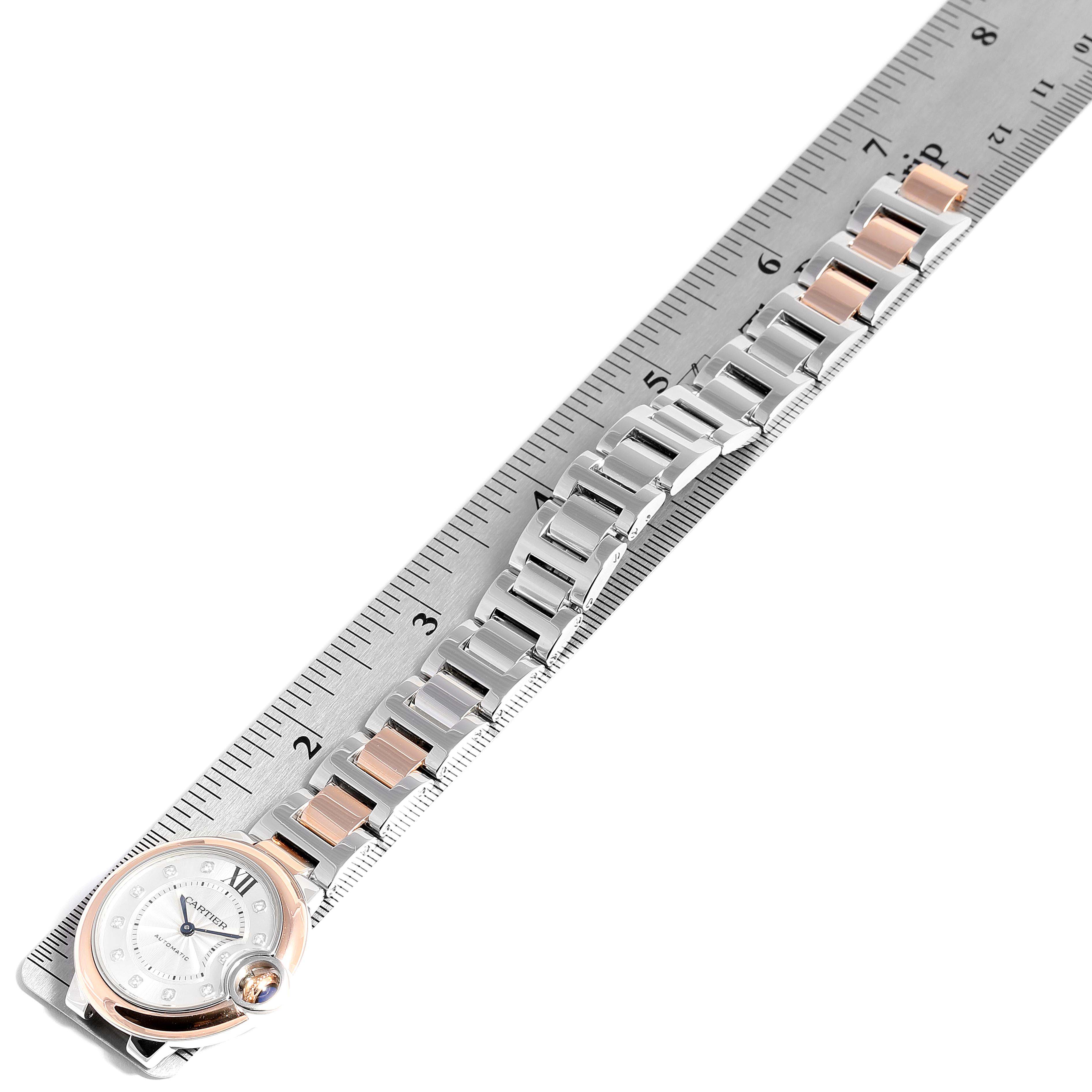 The image shows the face and metal bracelet of the Ballon Bleu by Cartier, placed beside a ruler for size reference.