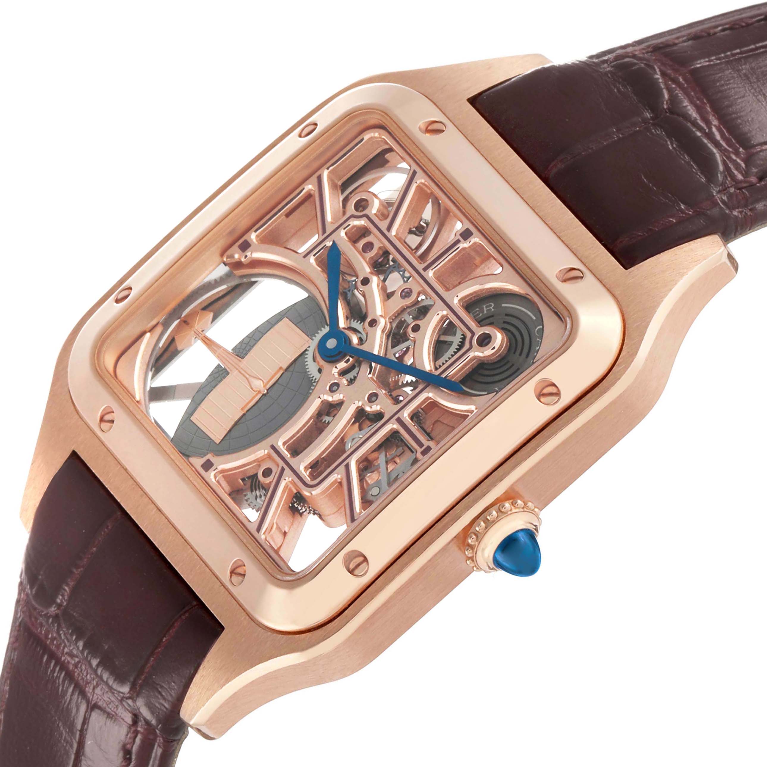 The Cartier Santos Dumont WHSA0030 Men's Rose Gold Transparent Dial watch is shown at an angled view, highlighting its skeleton dial, rose gold case, blue hands, and leather strap.