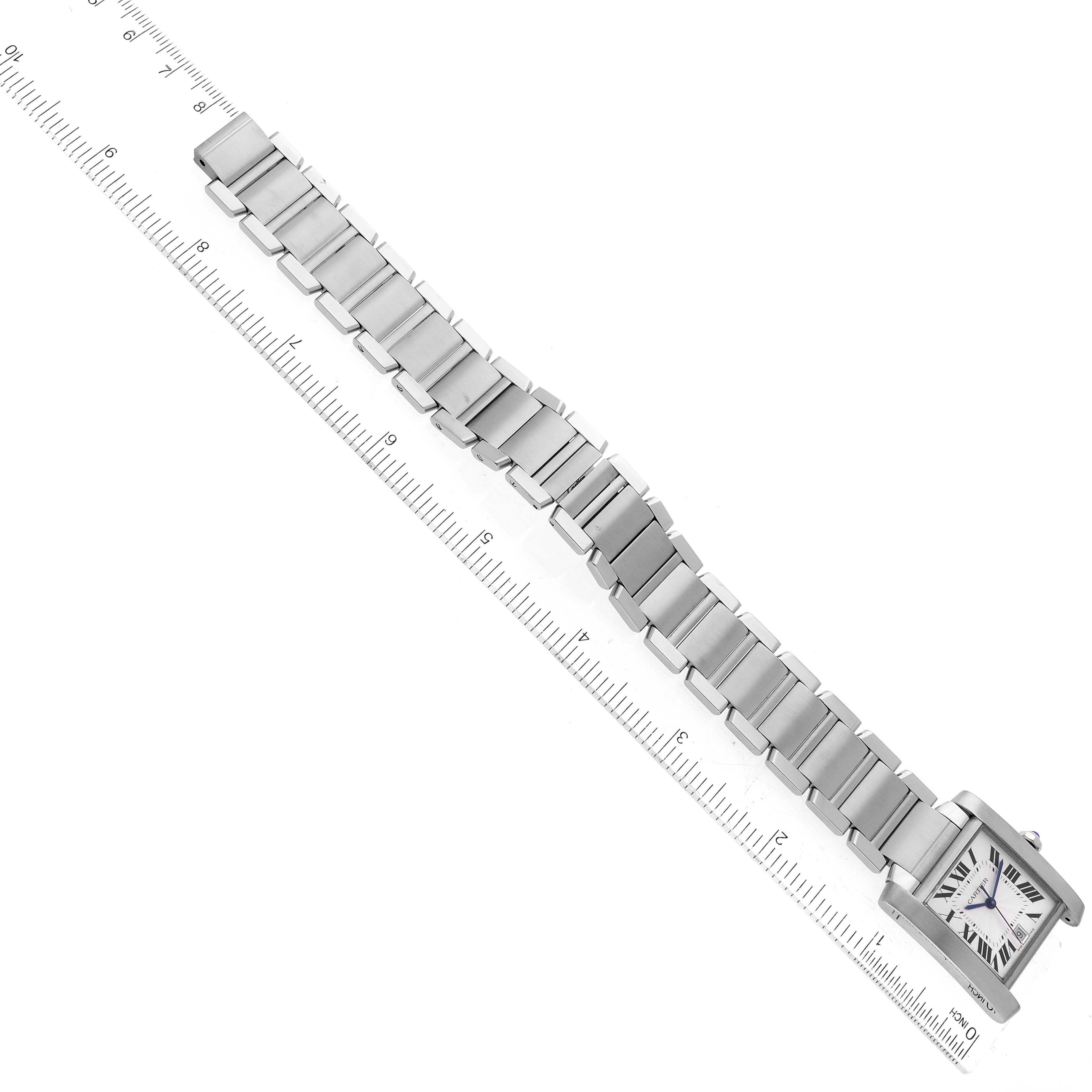 The Cartier Tank Française watch is shown from a top-down angle, displaying the face, bracelet, and ruler for measuring length.