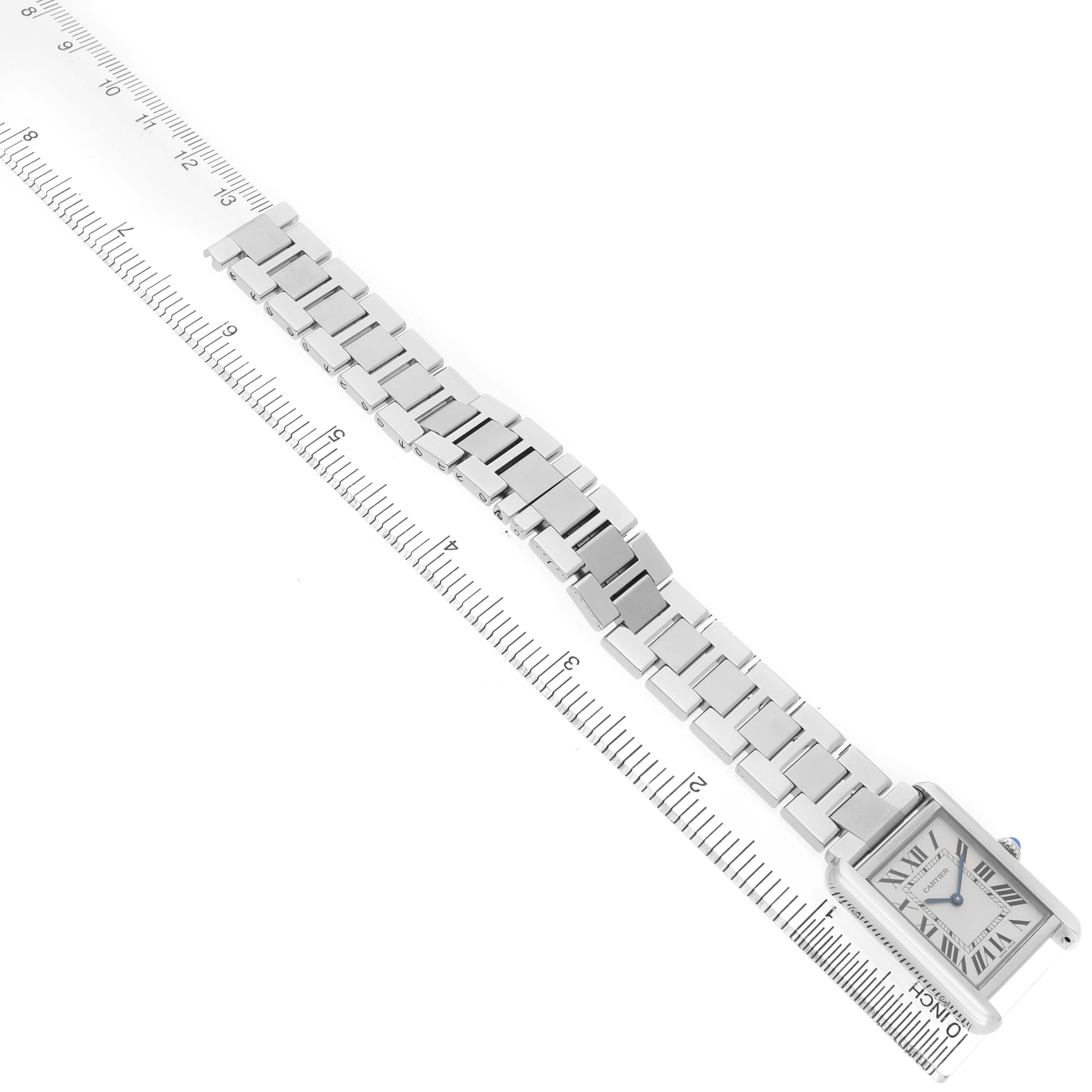The image shows a Cartier Tank Solo W5200013 Women's Stainless Steel Silver Dial watch from an angled top view, highlighting its rectangular face and metal bracelet on a ruler.