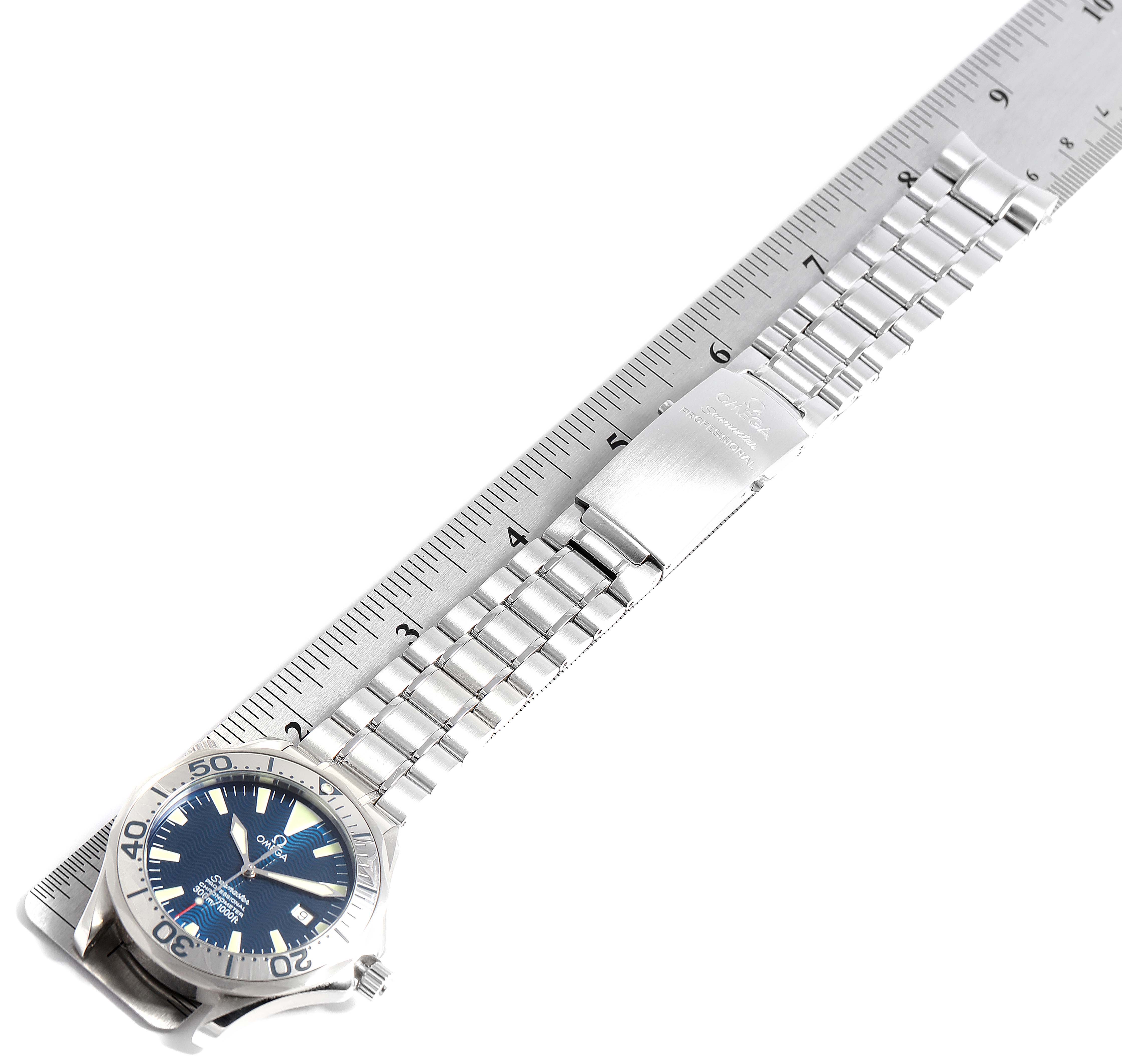 The Omega Seamaster 2255.80.00 Men
s Stainless Steel Blue Dial 2255.80.00 Men
s Stainless Steel Blue Dial watch is shown from a top-down angle, displaying the face, bezel, and bracelet alongside a ruler.